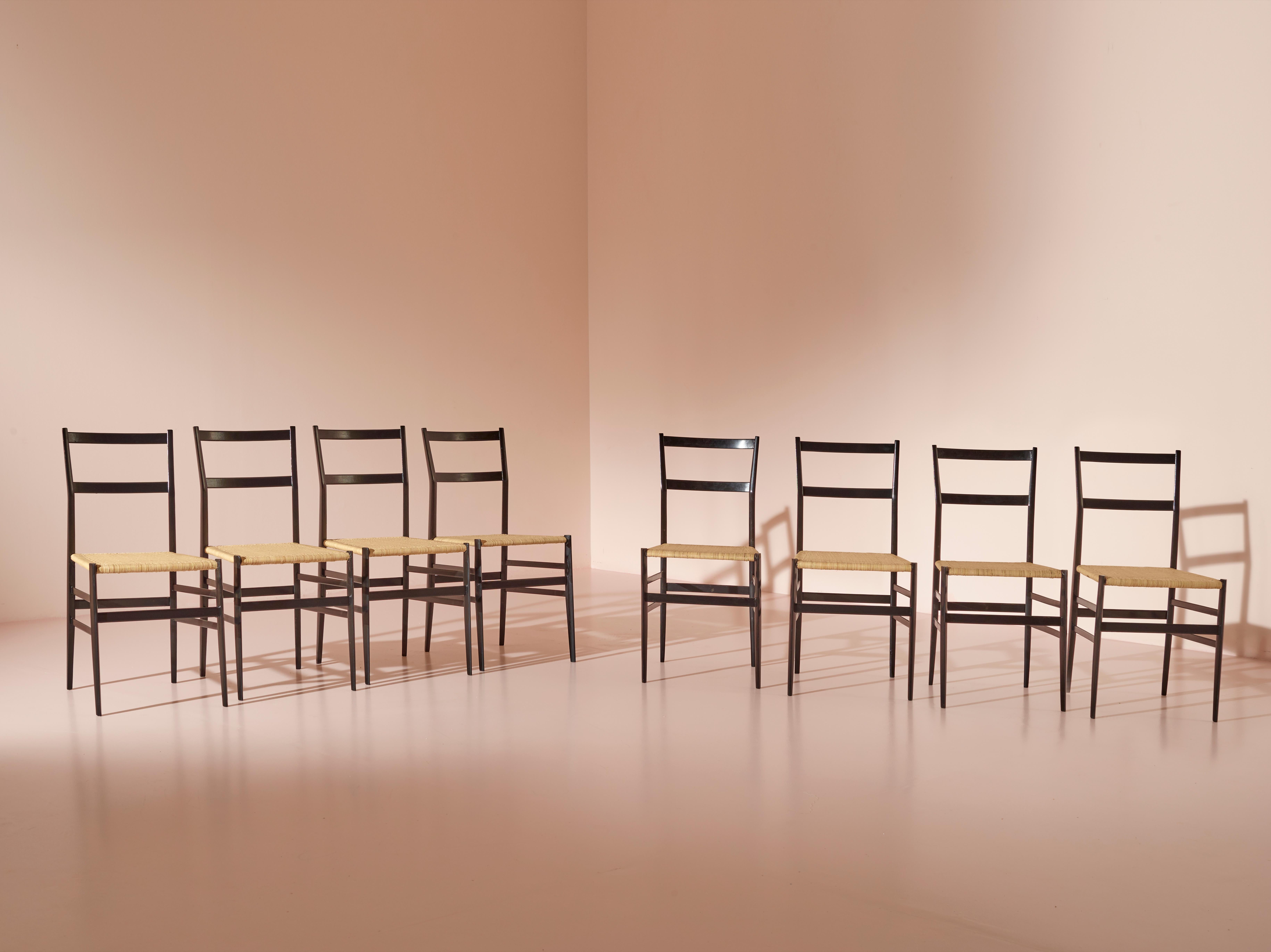 Un ensemble de huit chaises Superleggera, méticuleusement restaurées en peinture noire à l'aniline. Les sièges en paille tressée d'origine ont été remplacés par de nouveaux sièges méticuleusement fabriqués, conservant l'essence légère de la chaise.