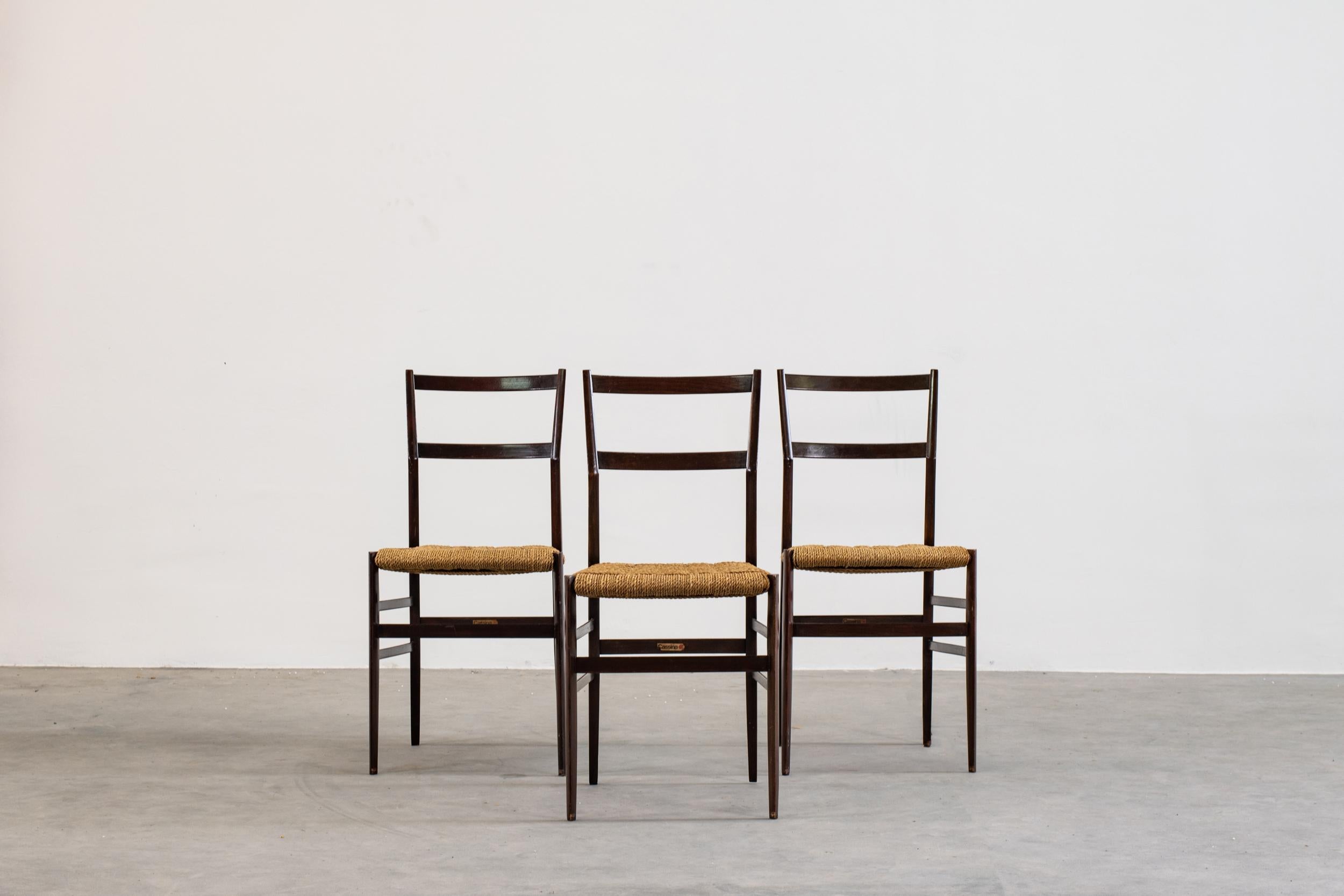 Set of three Superleggera dining chairs with a structure in solid lacquered ashwood, legs with a triangular tube of only 18 millimeters and minimum weight of 1,700 grams, and a seat in hand-woven straw.

Designed by Gio Ponti and manufactured since