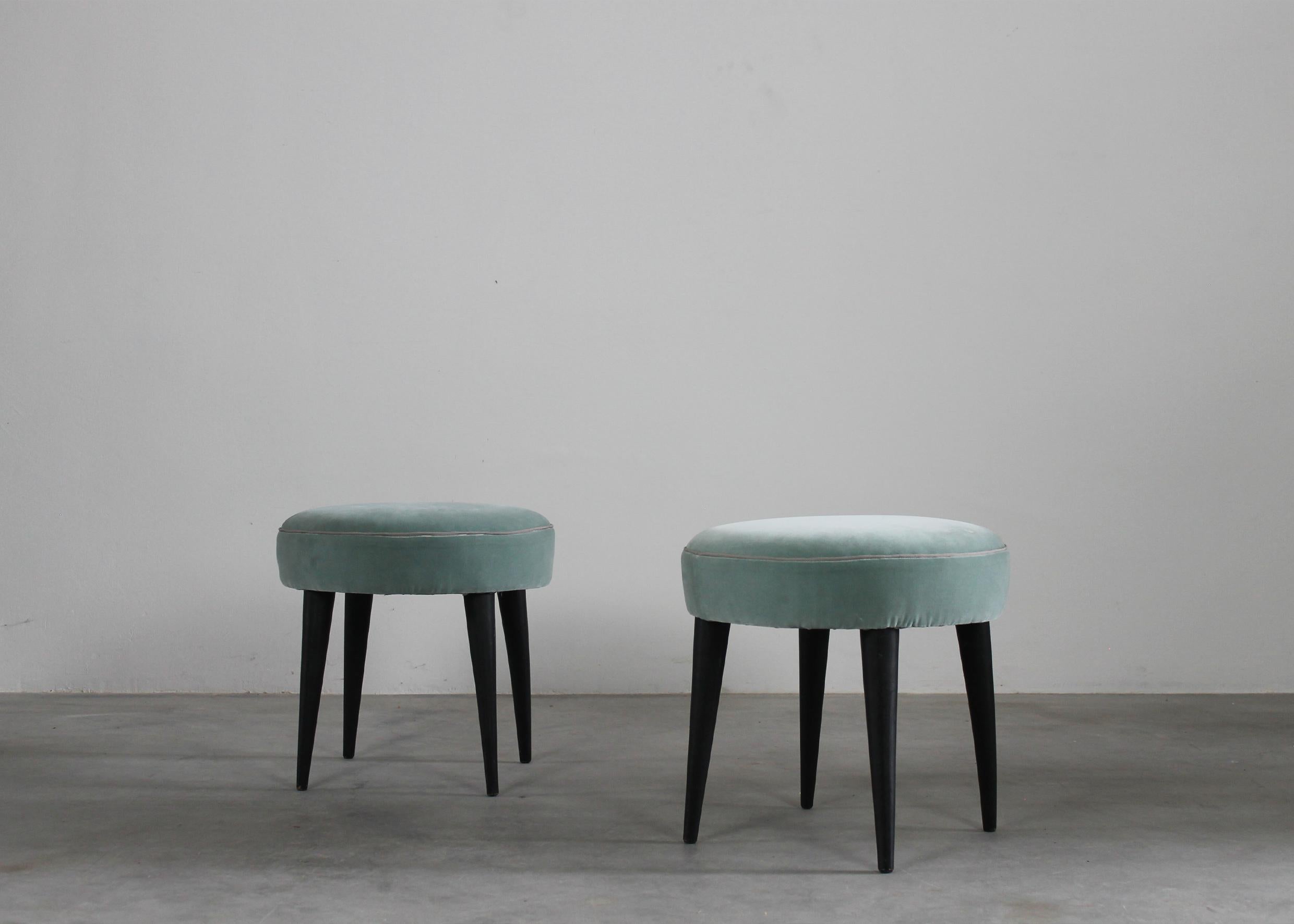 Set of two stools with legs in black lacquered wood and seats upholstered in light blue fabric. 

Attribuited to Gio Ponti, Italian Manufacture 1950s 

Gio Ponti was an icon of the modernist movement: the Italian designer, architect, artist and