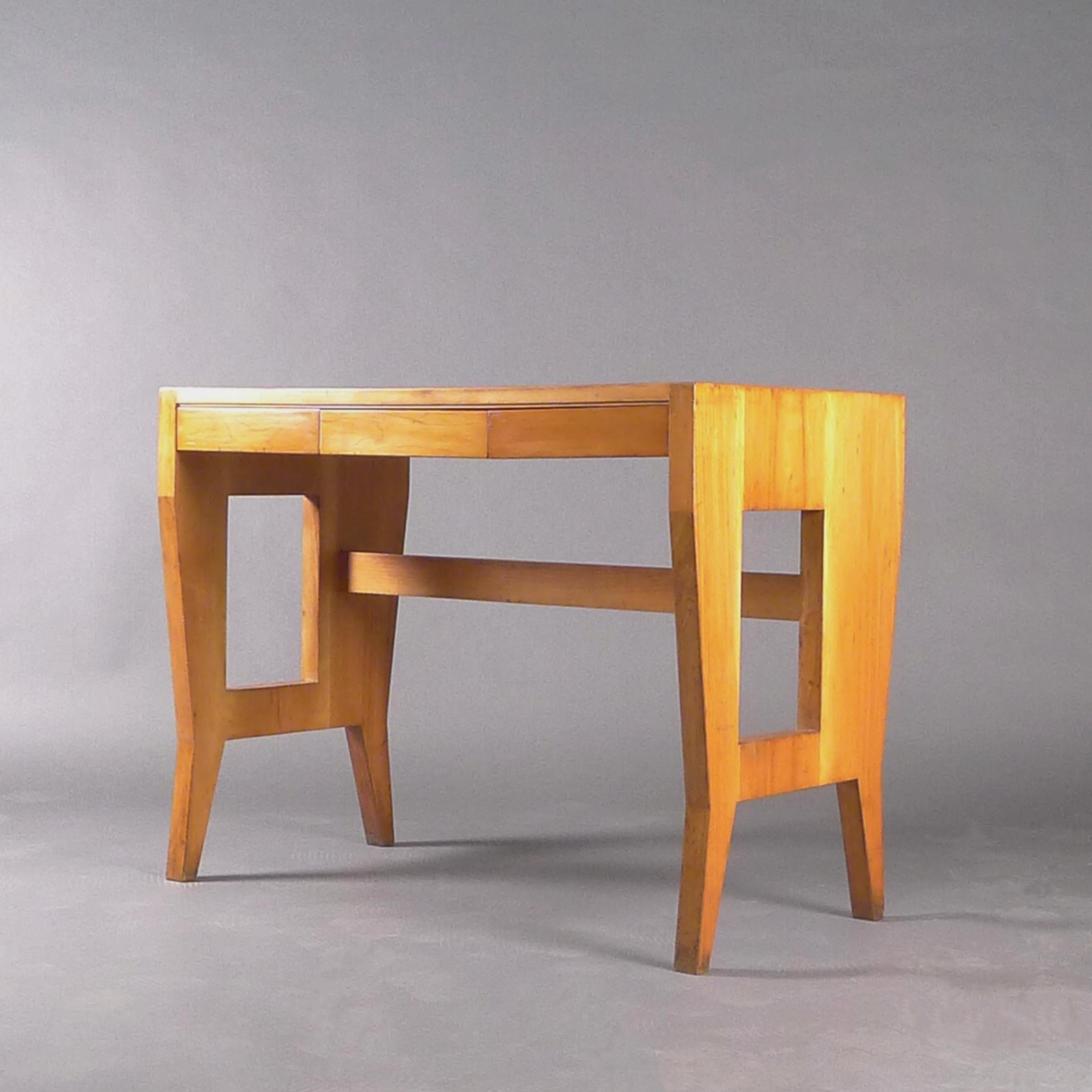 Gio Ponti small desk in light walnut on shaped tapering legs united by stretchers.  The wood is in excellent condition with beautiful graining to the planked top, and the three frieze drawers to the front slide smoothly.

140cm wide, 70cm deep, 80cm