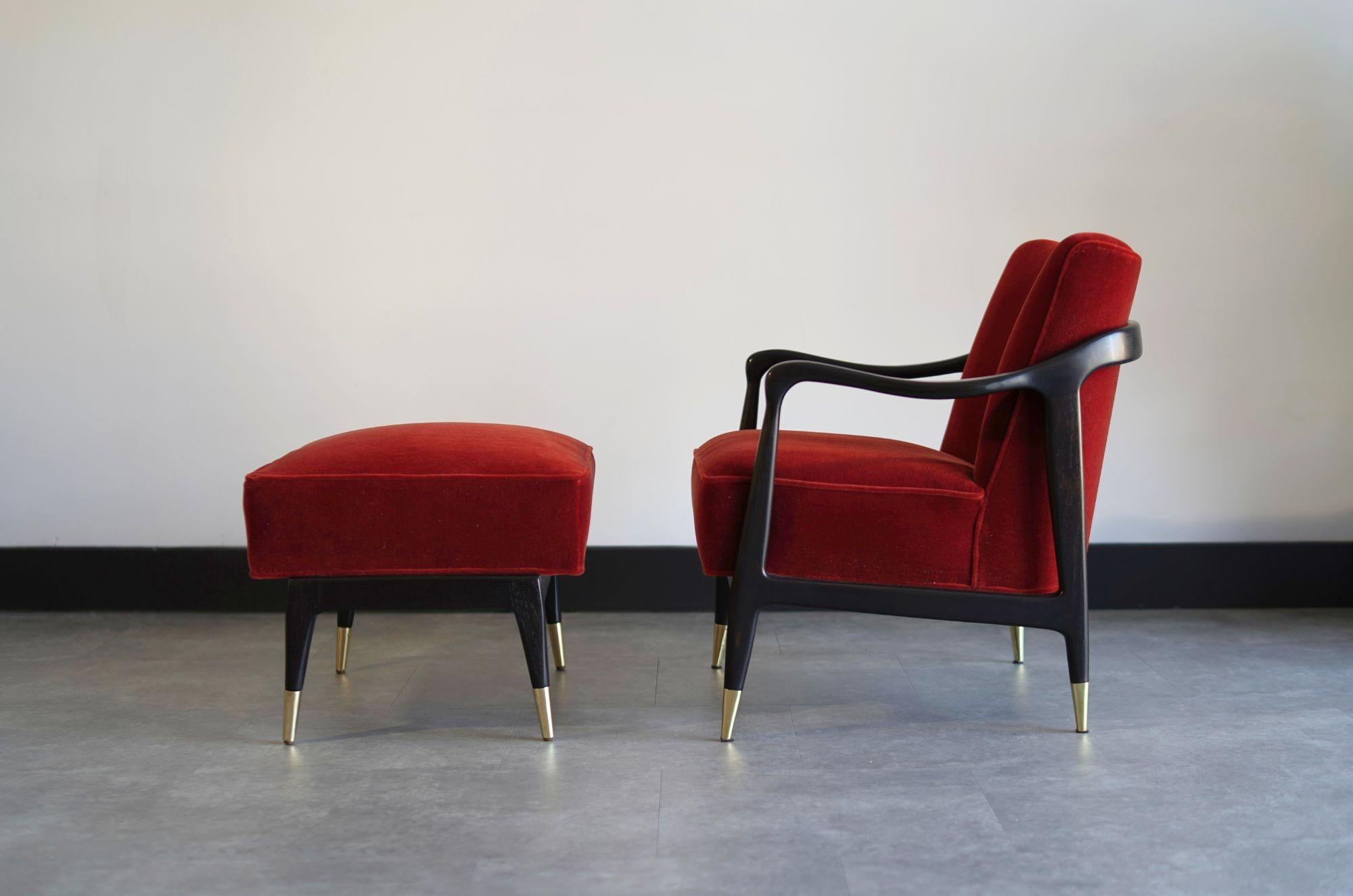 Este llamativo sillón de salón, acompañado de un reposapiés a juego, presenta un escultural armazón de nogal restaurado y repintado por expertos en un rico tono espresso, acentuado por elegantes sabots de latón. Tapizada en lujoso mohair rojo óxido,