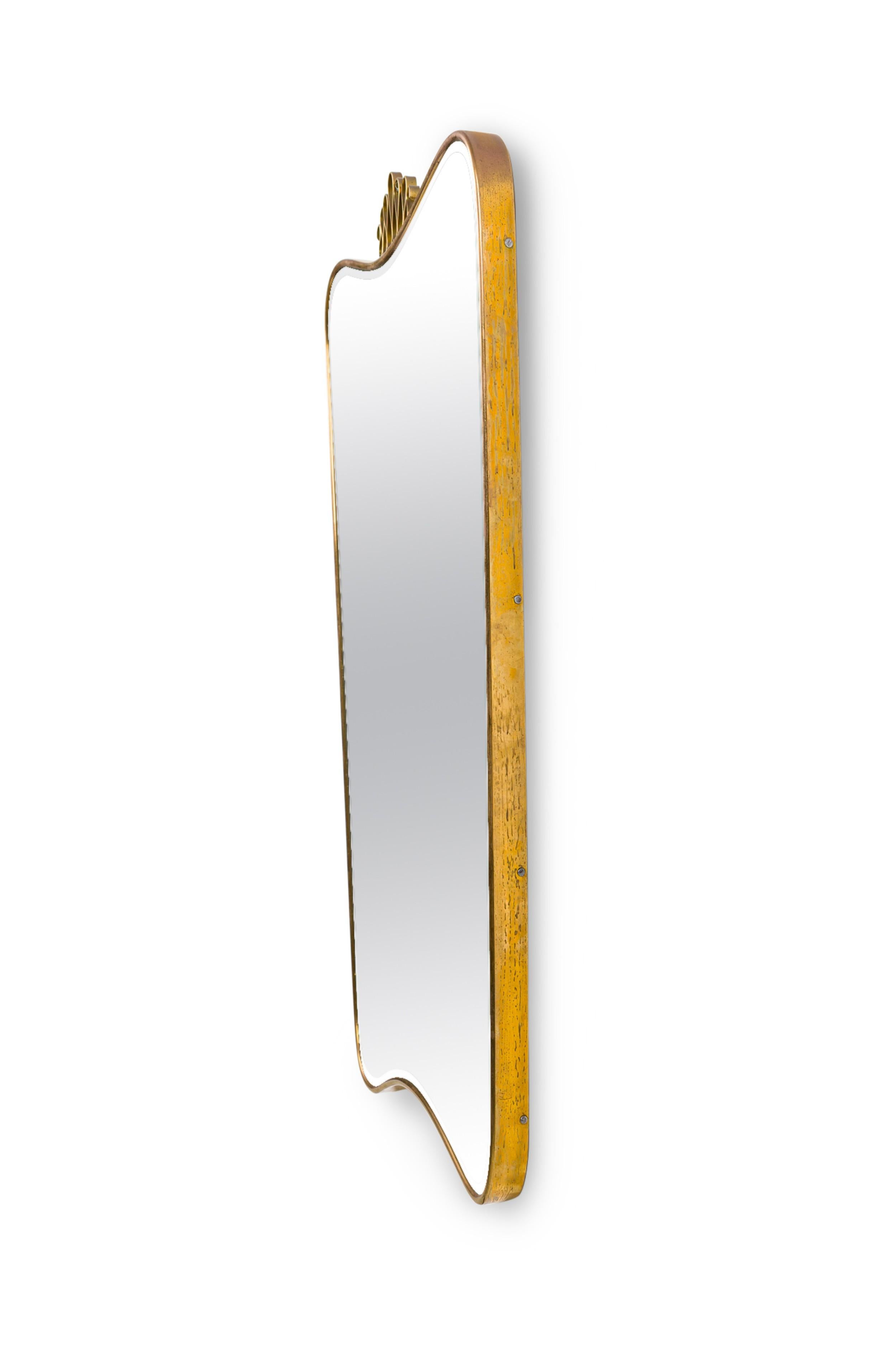 Specchio da parete rettangolare in ottone della metà del secolo scorso, con parte superiore e inferiore sagomata e frontone a forma di anello aperto (att: Gio Ponti)