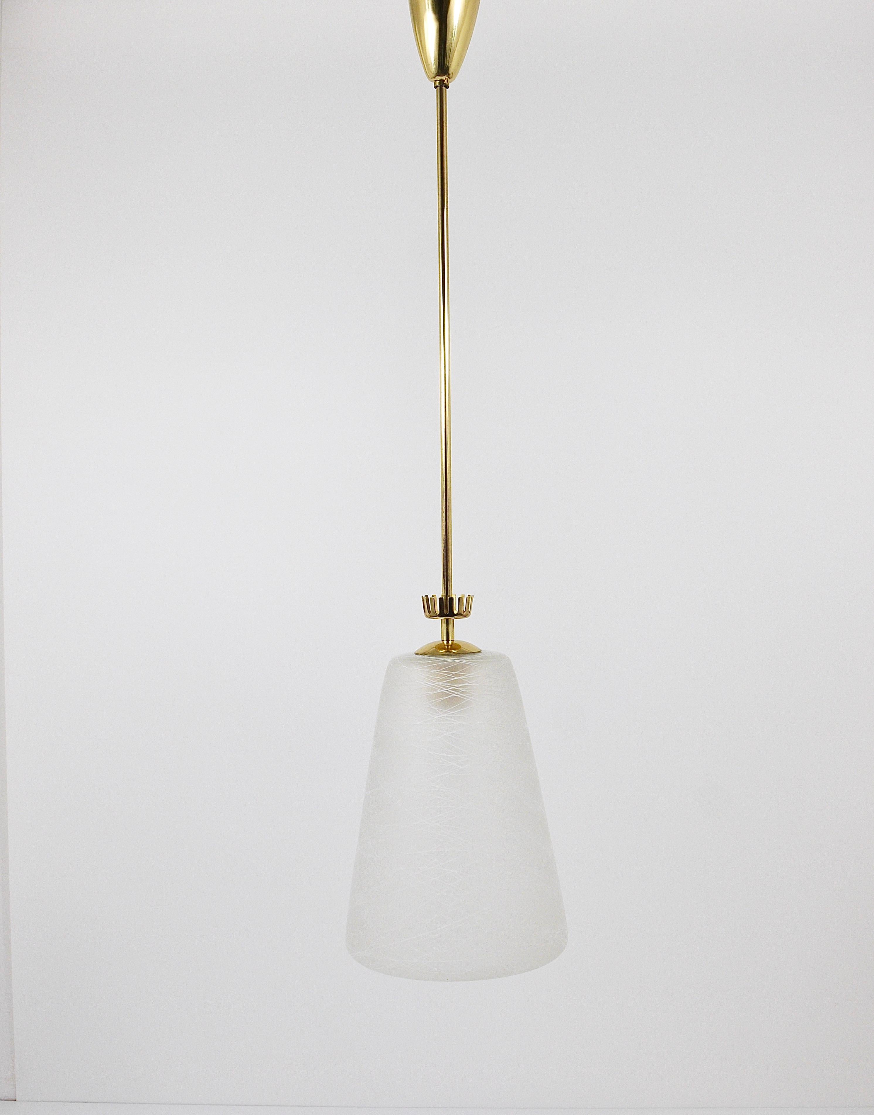 A charming Italian modernist ceiling light from the 1950s. Made of polished brass, it has a conical satined lampshade with a wonderful etched Mid-century pattern on it and a nice little brass crown on its top. The fixture offers one light source and