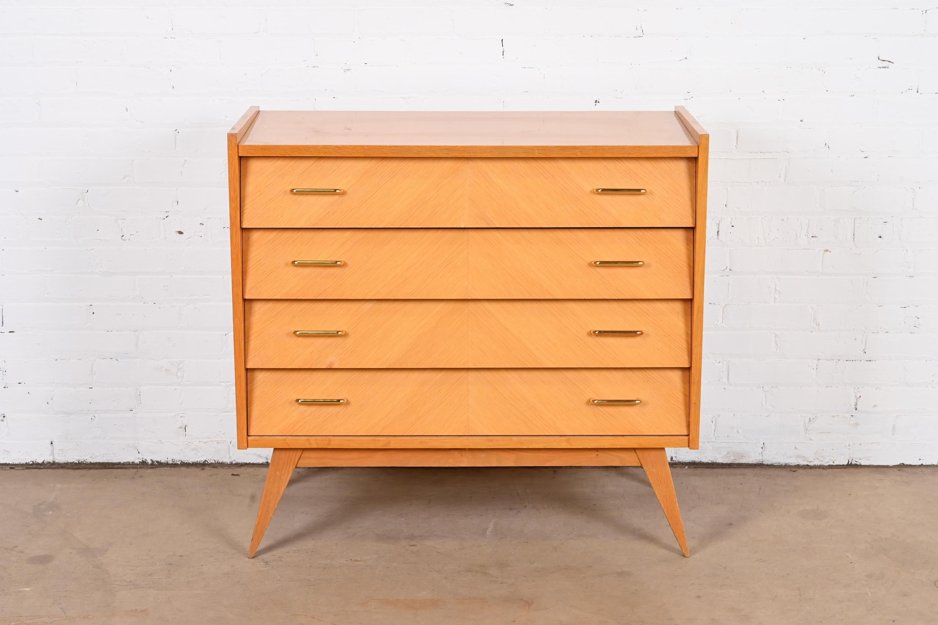 A sleek and stylish Mid-Century Italian Modern louvered front dresser or chest of drawers

In the manner of Gio Ponti

Italy, Mid-20th Century

Oak case, with book-matched maple front drawers and brass hardware.

Measures: 37.38