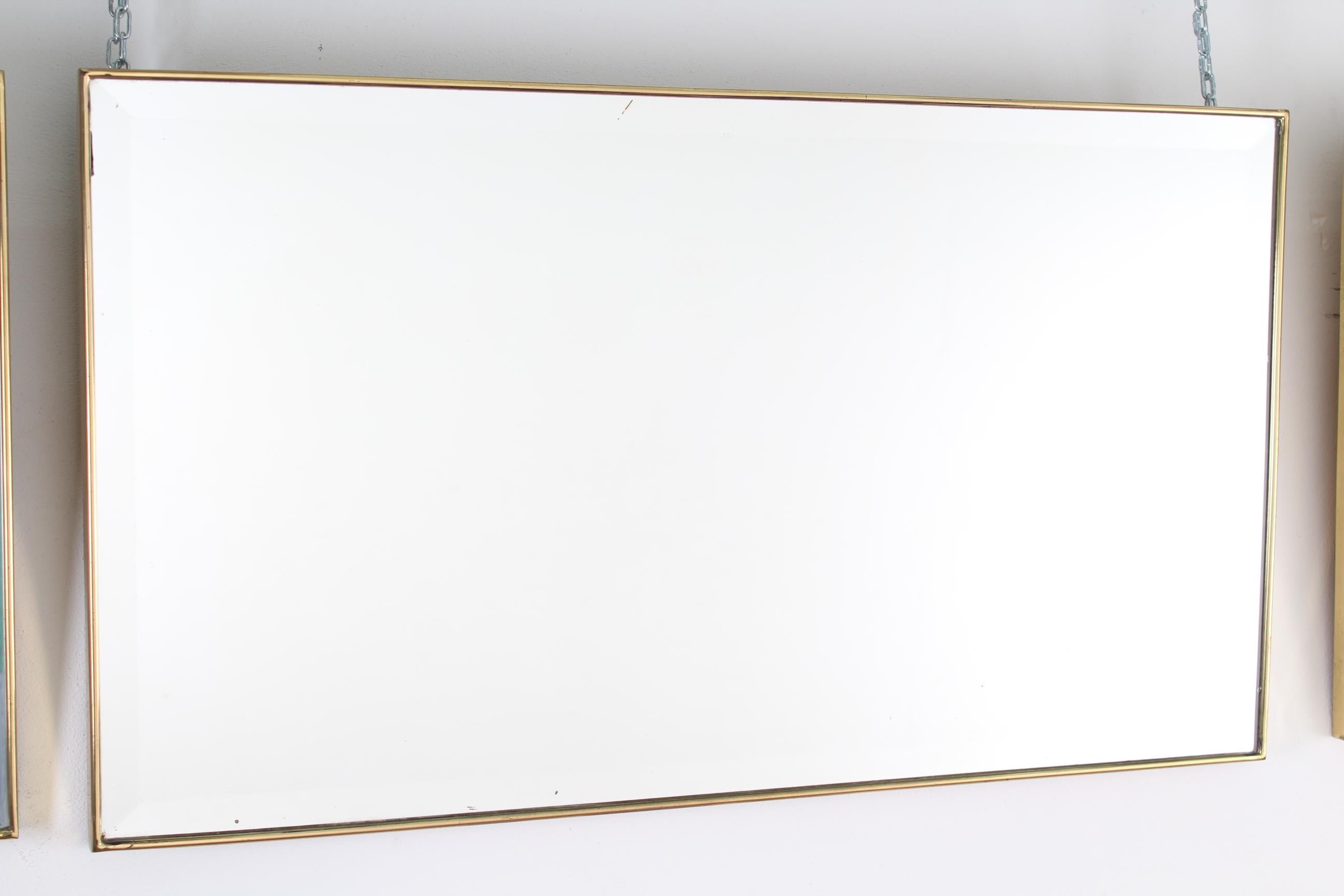 This is a large mid-century Italian wall mirror with a brass frame from the 1950s. The mirror has a rectangular shape, bevelled at the edges, classically elegant and distinct in a modern Gio Ponti style.
Wear consistent with age and use.