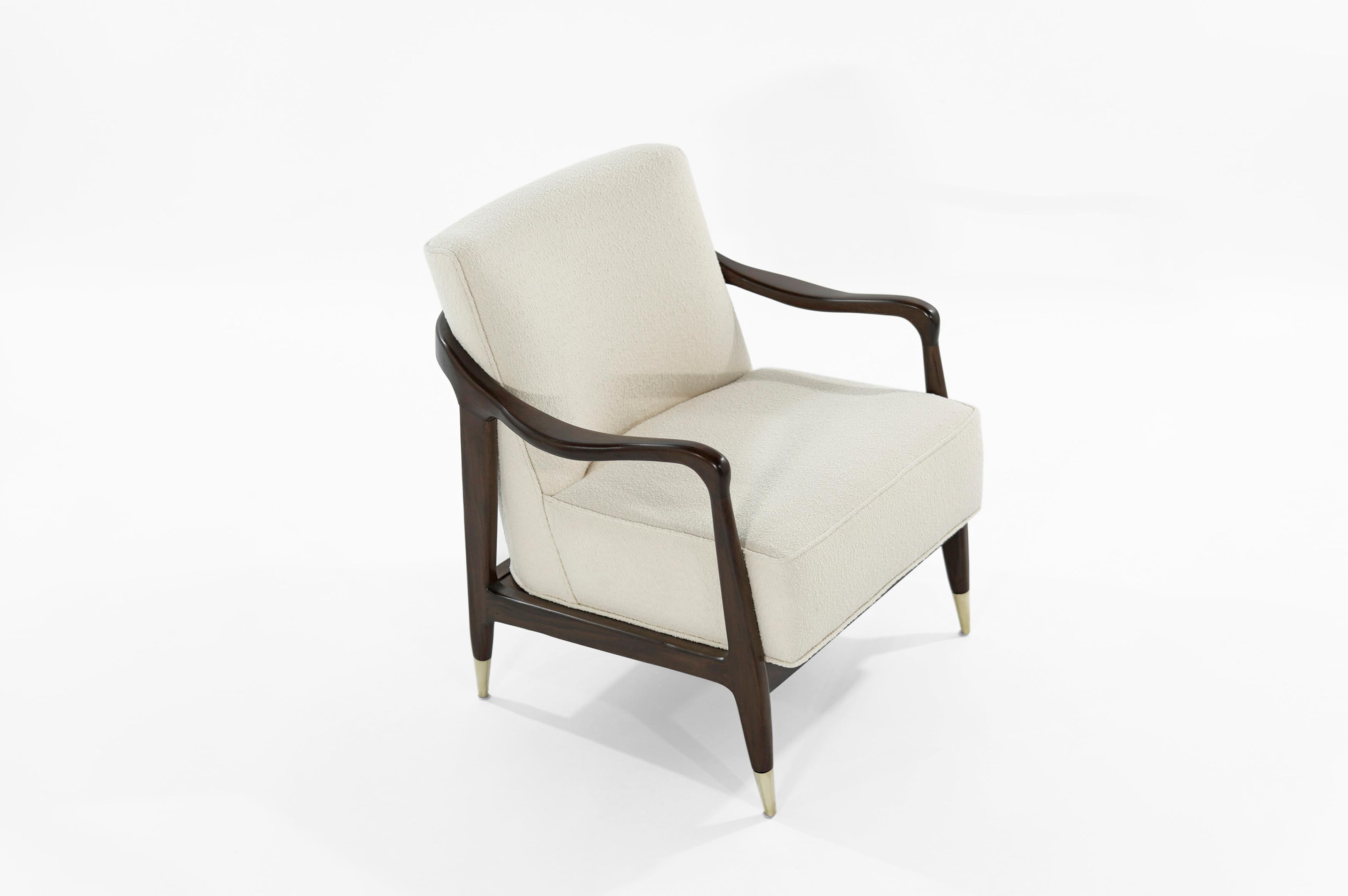 Exquisite Mid-Century Modern lounge chair featuring sculptural walnut frame, which has been expertly restored to their original integrity. It boast new handcut high grade foam, as well as hand polished brass sabots. Newly upholstered in cream