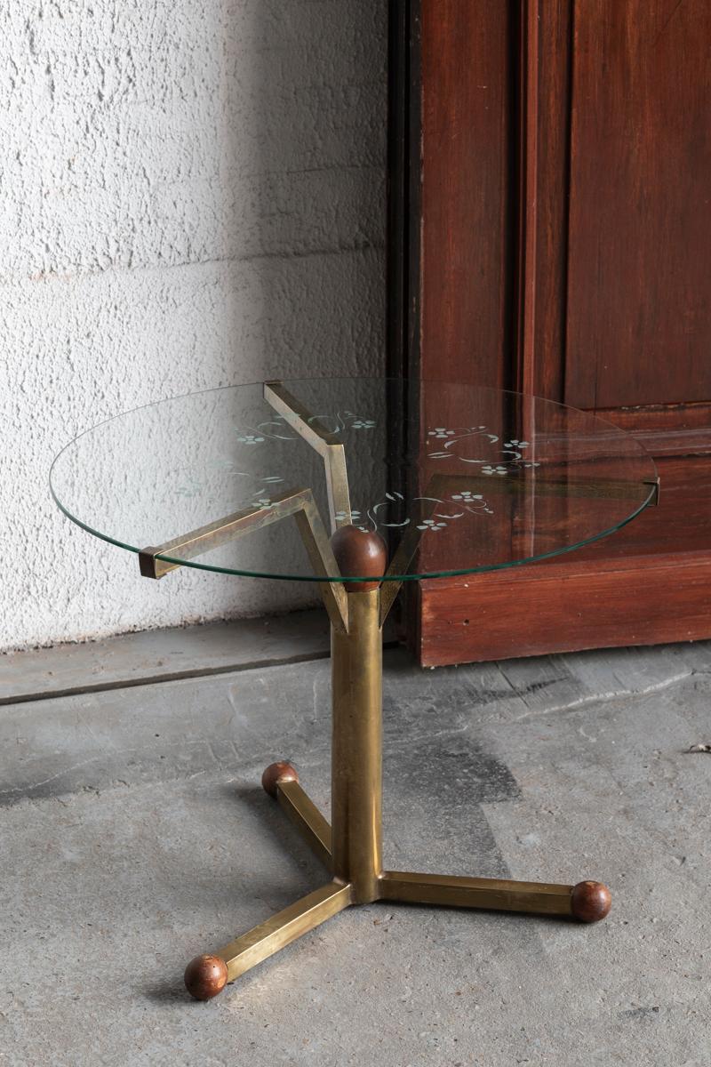 Round side table designed and produced in the Italy around 1950. This piece features a brass base with wooden details. The glass top is etched with a floral design. The design is reminiscent to the style of Gio Ponti and Peter Ghyczy. In good