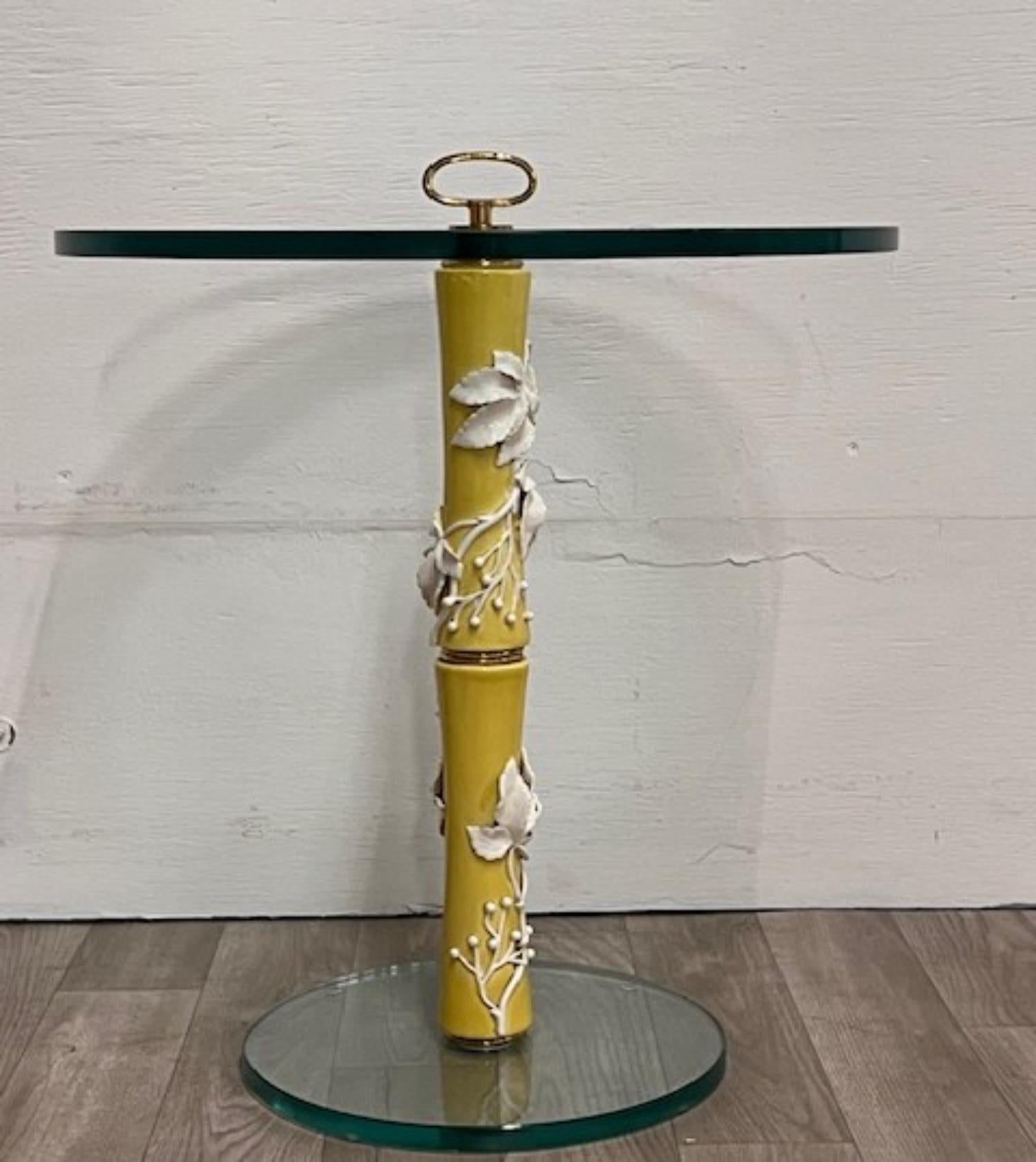 Elegant side table feautring a yellow porcelin design with white flowers and a glass top with brass details
Attributed to:
Designer Gio Ponti
Manufacturer Richard Ginori

Pair Available 