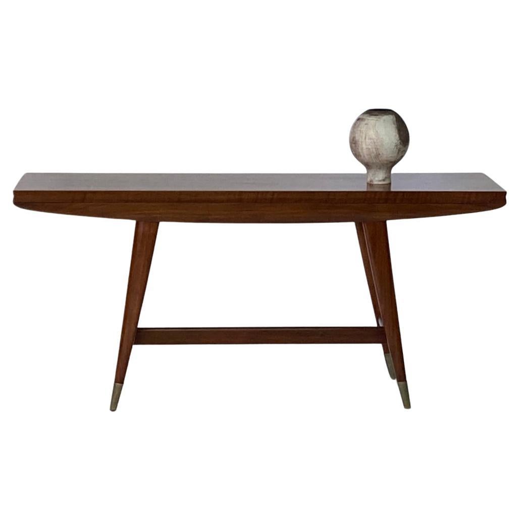 Gio Ponti (italiano 1891-1979)
Consola/mesa de comedor abatible de nogal
Modelo 2134 para Singer & Sons, años 50
La parte superior, de latón y con bisagras, está sobre un friso perfilado y se eleva sobre patas ahusadas unidas por un bastidor en