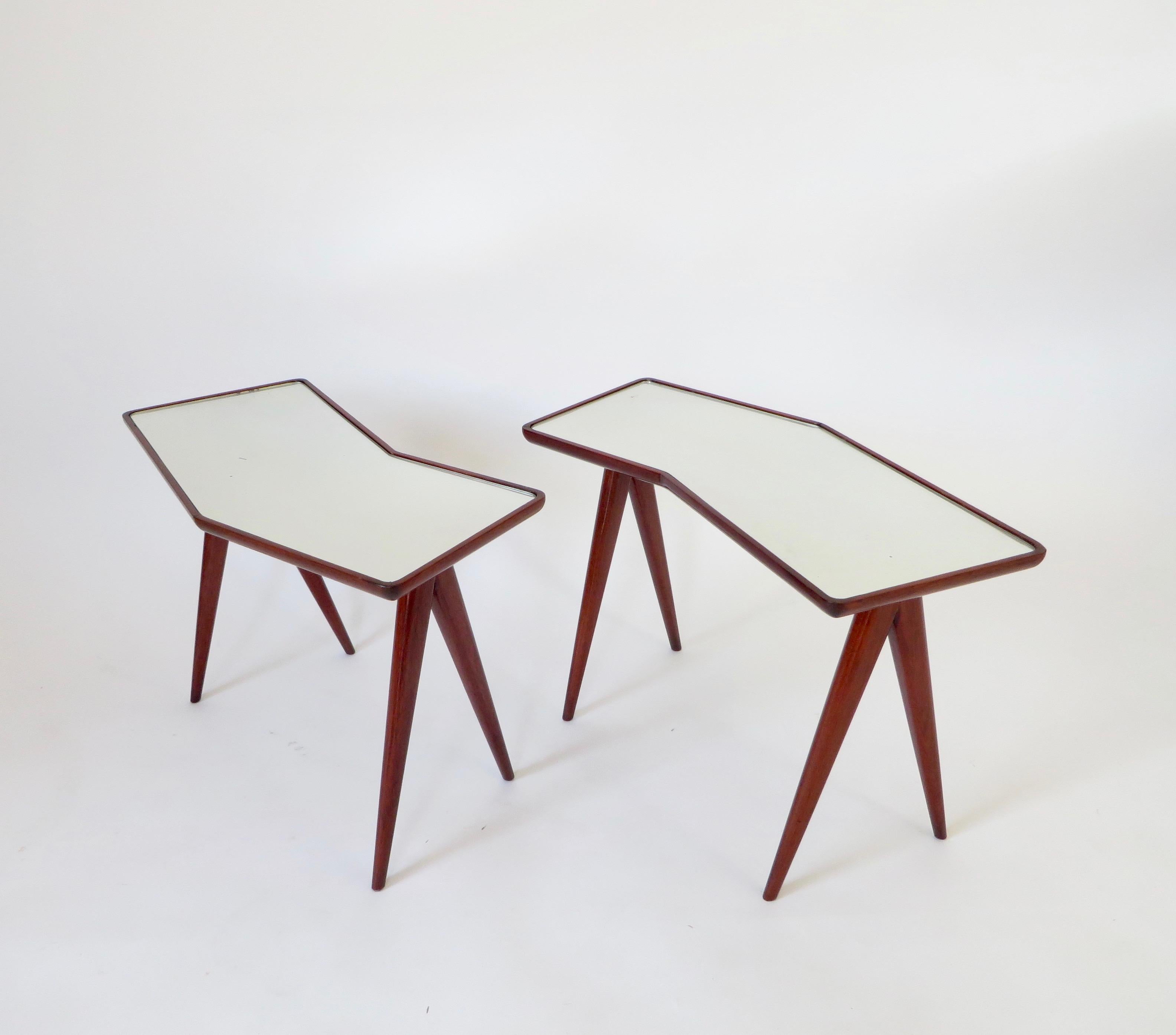 Pair of Italian master architect Gio Ponti walnut side tables with mirrored glass tops by Pietro Chiesa. All original.
The mirrored glass reflects the light and whatever is positioned on it.
The walnut legs splay in iconic Ponti fashion and form a