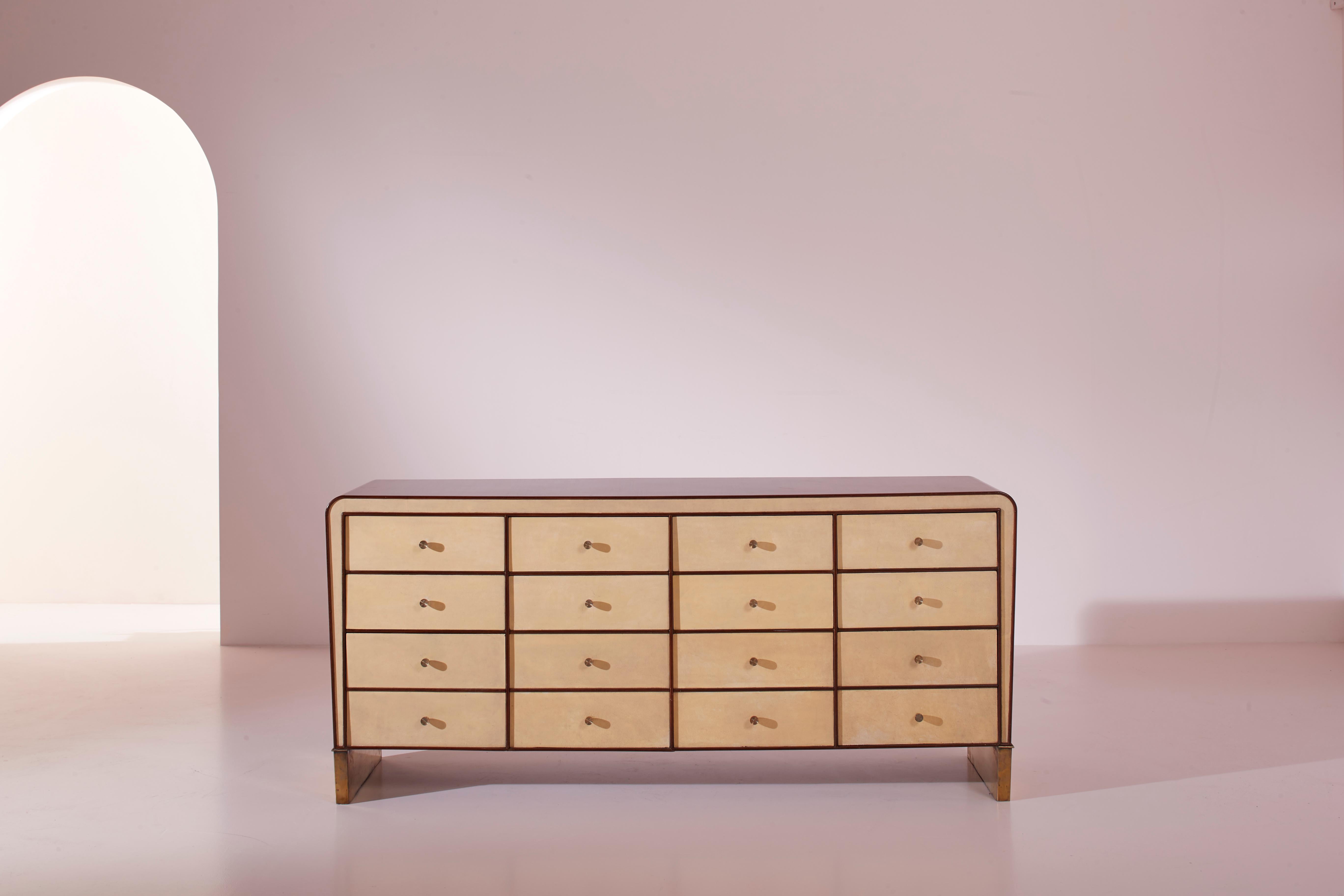 Chest of drawers in American walnut, parchment, and brass, designed by Gio Ponti in the 1930s and produced in Italy.

Elegant and slender, it rests on polished metal triangular feet, showcasing the mastery in combining three materials that blend