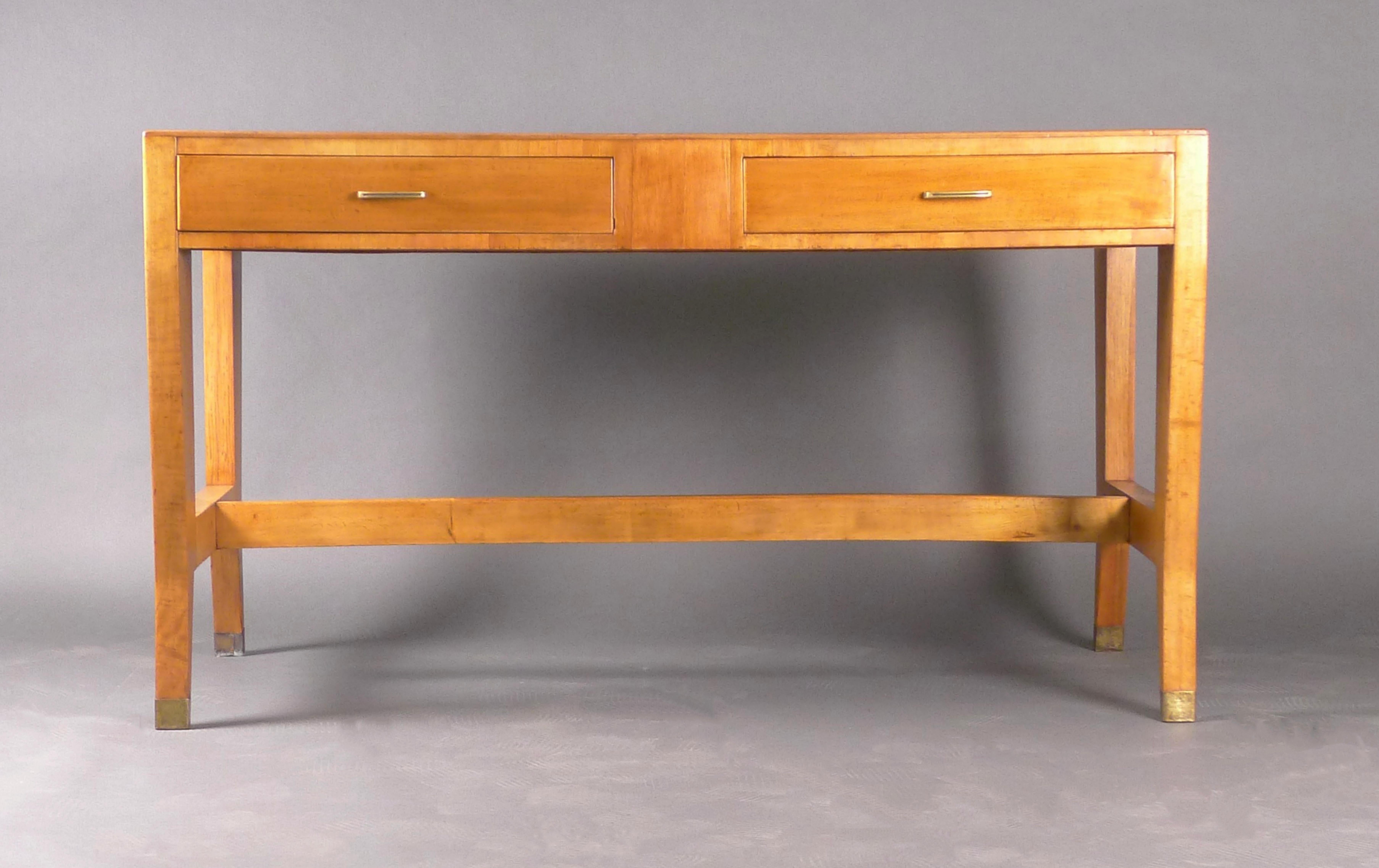 Gio Ponti desk in light walnut on shaped tapering legs united by stretchers.  The wood is in excellent condition with beautiful graining to the planked top, and the two drawers to the front slide smoothly, pulled with brass loop handles.

140cm