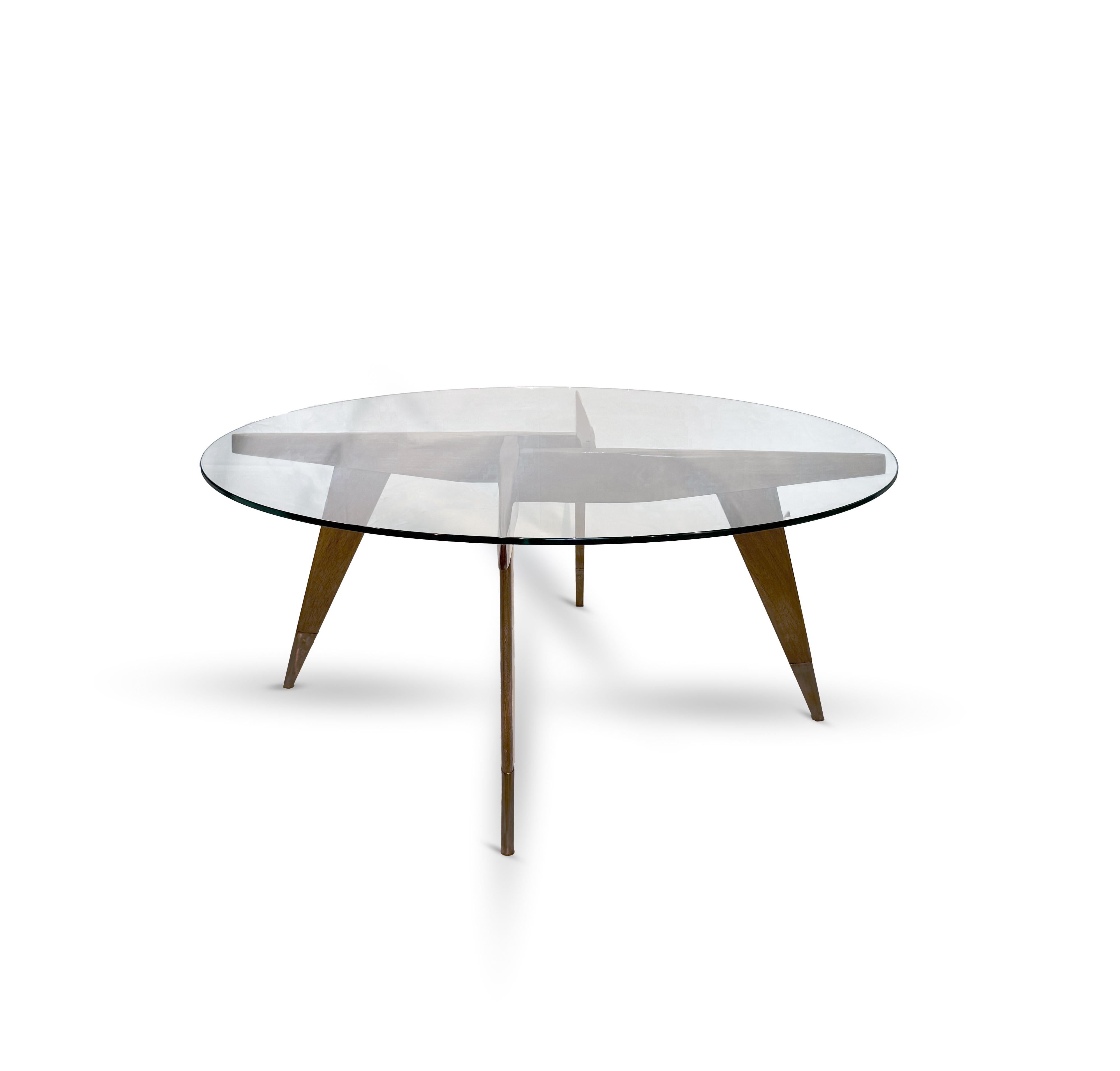 This elegant and iconic round coffee table, designed by Gio Ponti circa 1954, exemplifies the refined Italian modernism of the mid-20th century. Crafted in Italy by Giordano Chiesa, the piece features a sculptural walnut base consisting in four legs