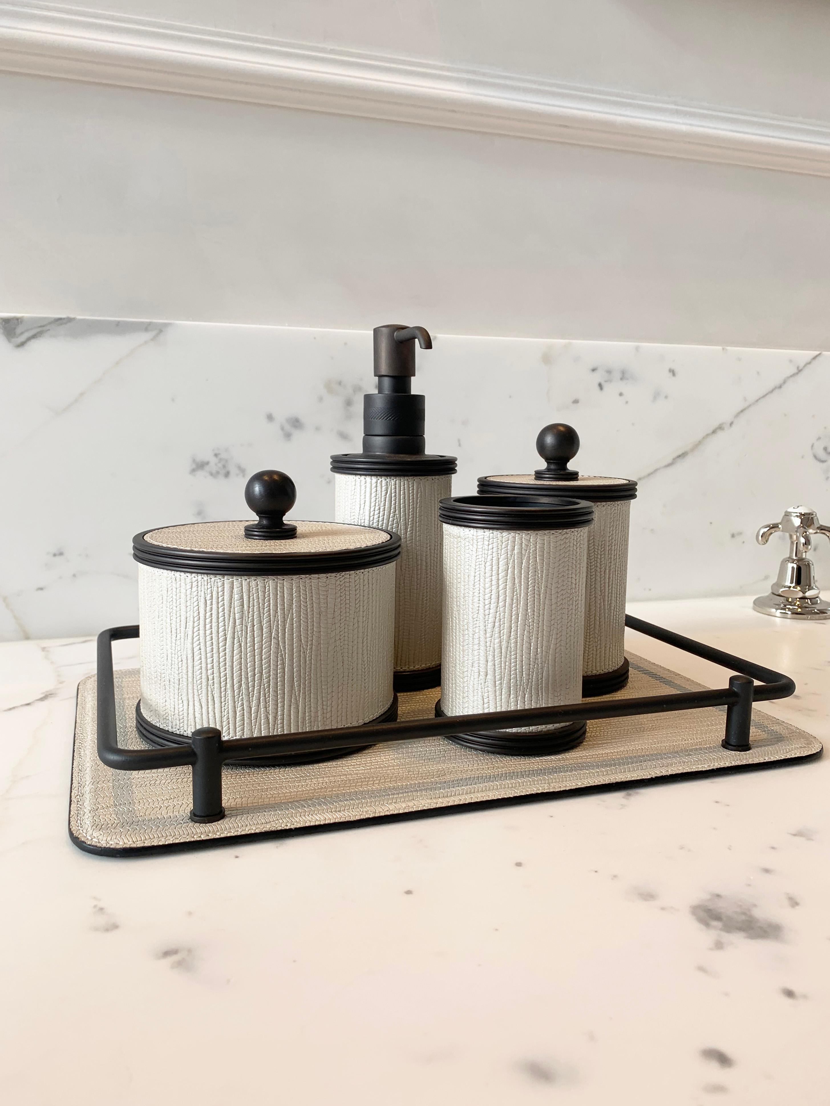 Amalfi bathroom set by Giobagnara. In leather, brass, and bronze.

This luxurious bathroom set is made up of a soap dispenser, toothbrush holder, two lidded dishes; in two different sizes, tray, an oblong tissue box cover, and bath bin.

All