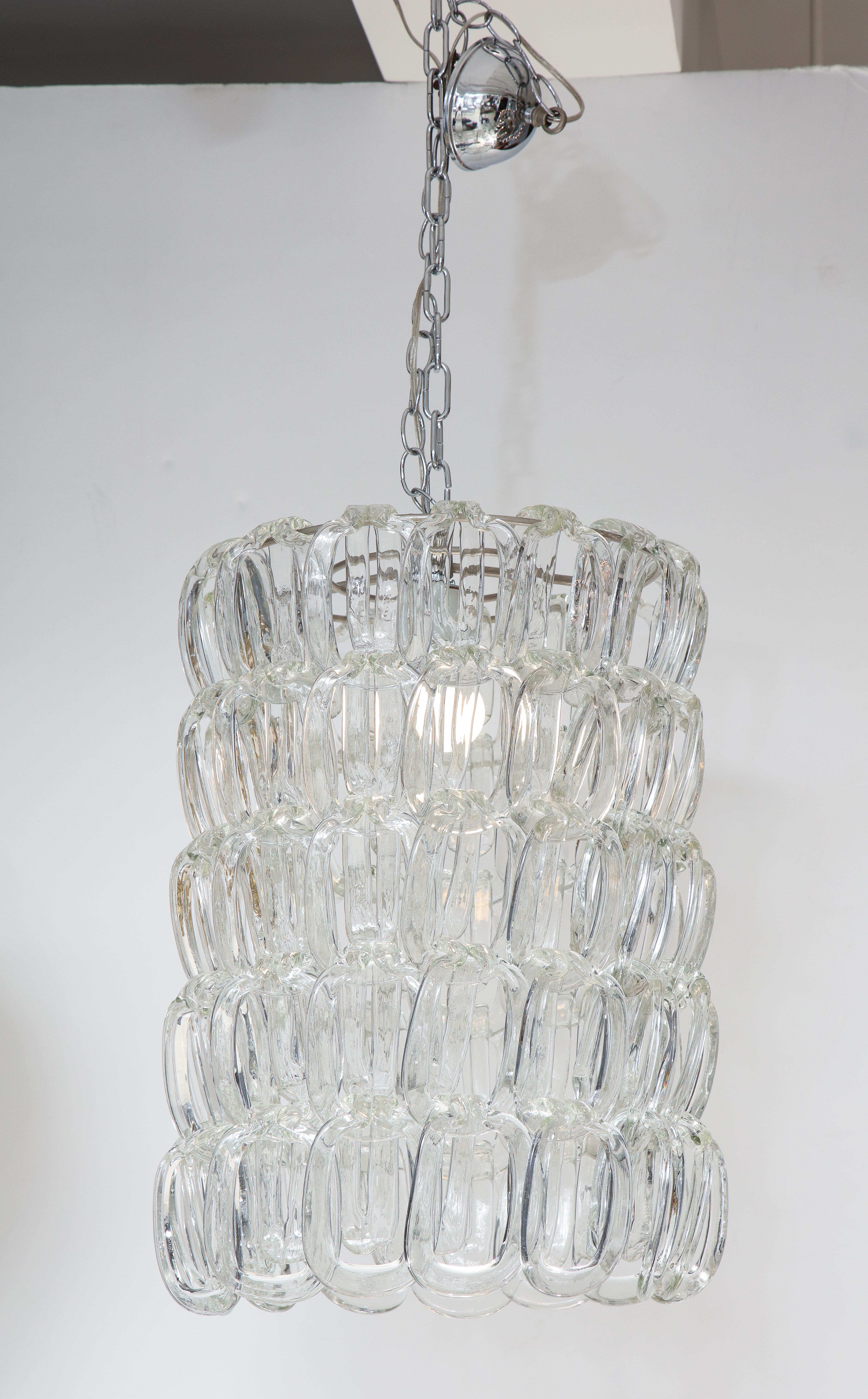 The Giogali chandelier by Angelo Mangiarotti, (1921-2012) for Vistosi, the Murano glass links display as double horseshoe rings, supported by metal interior rings. (Re-wired for USA standards). The glass length, displayed here with 4 levels can be