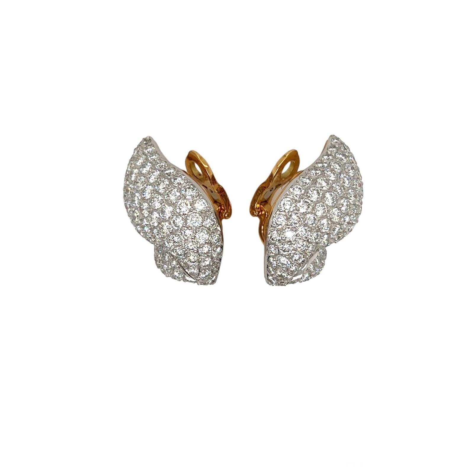 A pair of 14 karat yellow and white gold and diamond earclips, Gioia.  Each earclip designed as a large sinuous motif nesting a small sinuous motif, pave set all over with approximately ninety four (94) white gold set brilliant cut diamonds, with a