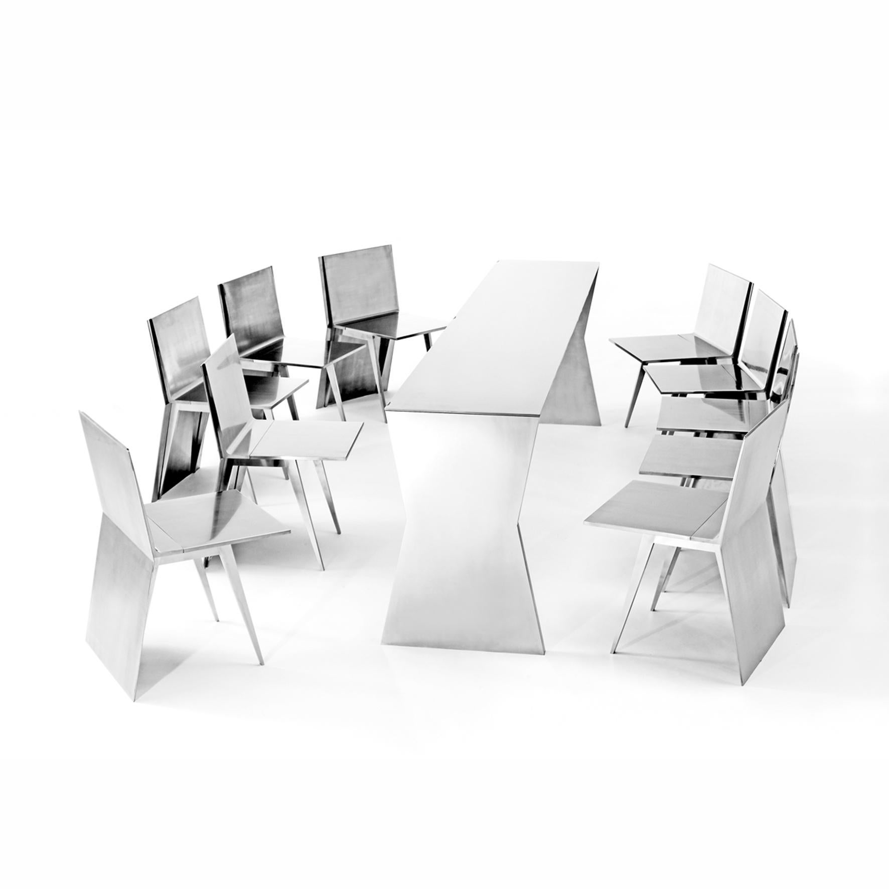 Gioia Meller Marcovicz
 
The Monolith
 
A stainless steel dining ensemble composed of a folding x-shaped profiled table and ten folding chairs. When nested under the rectangular top, the chairs create a monolithic block. 
 
This extraordinary