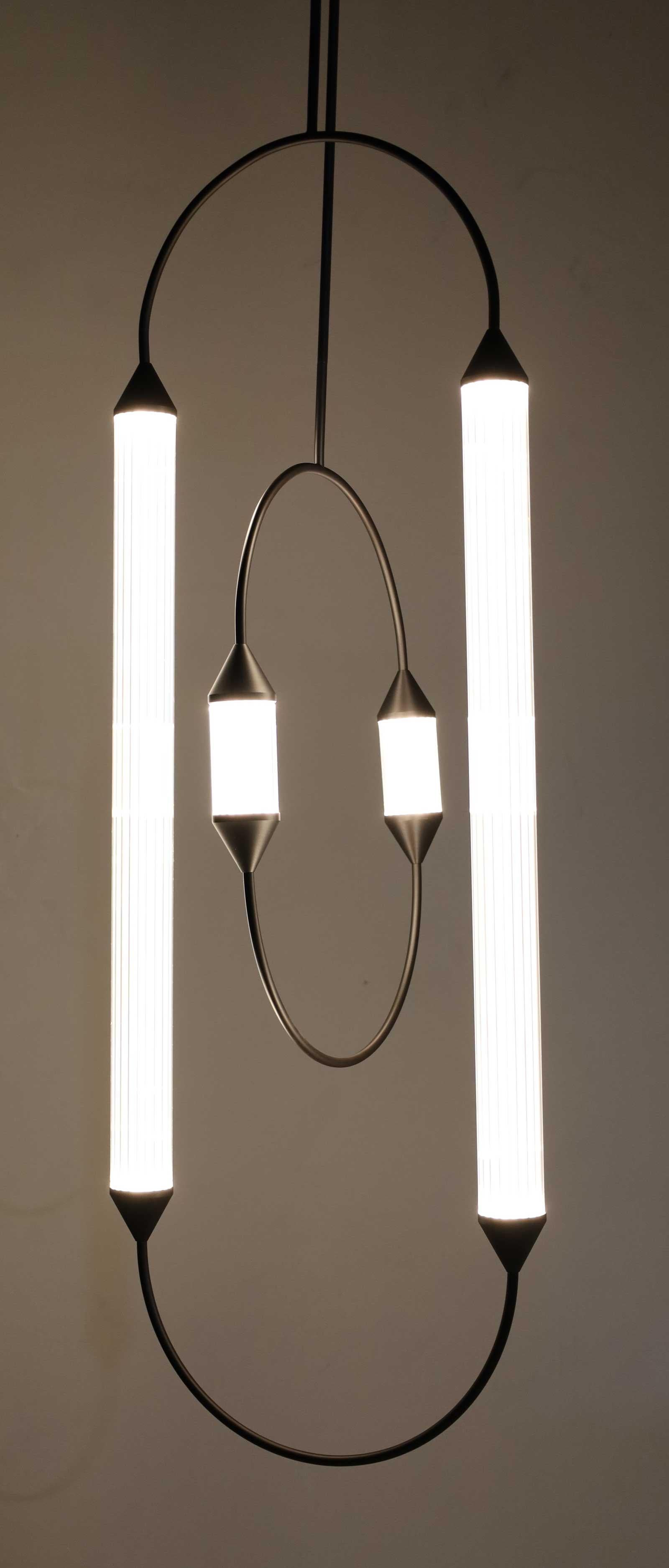We have two of these, while not identical, they compliment eash other. They are quite dramatic over a table. From their website:

Back to the magic of acrobats. Looking up, immersed in the darkness gazing at their infinite vaults. They draw circles