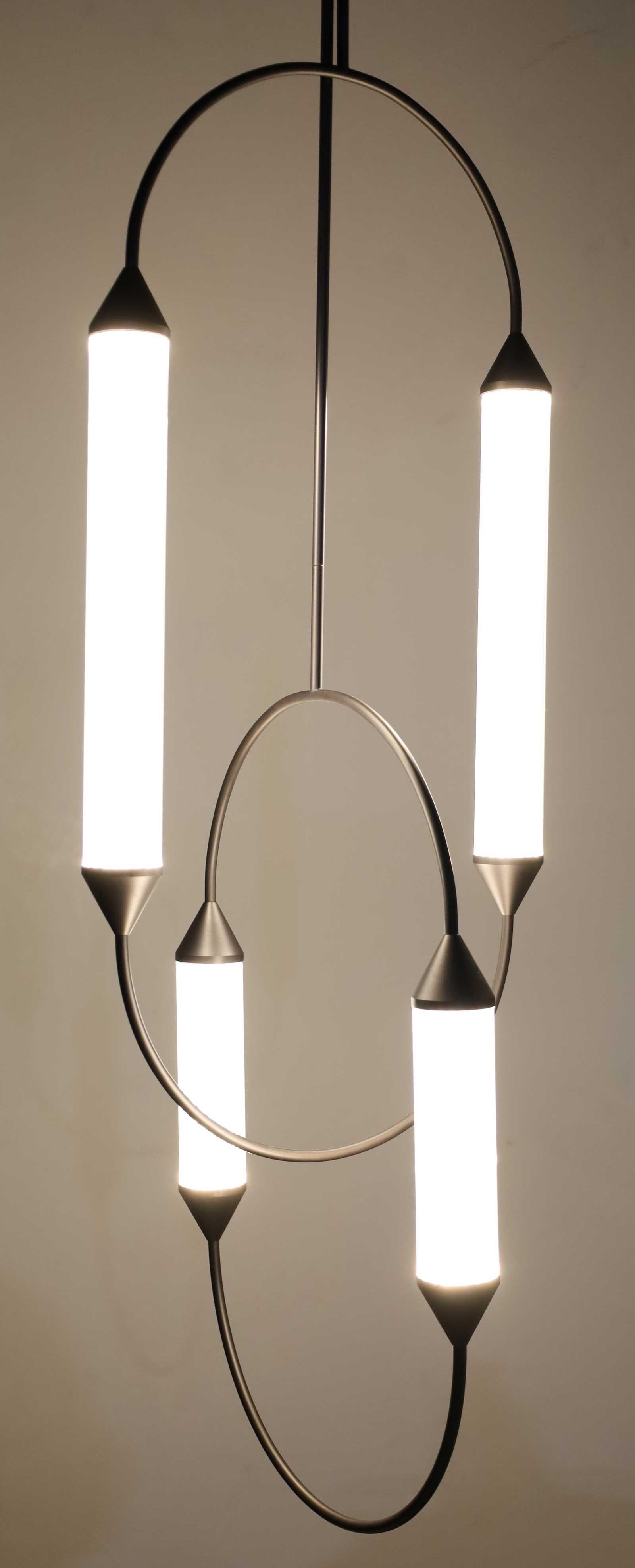 We have two of these, while not identical, they compliment eash other. They are quite dramatic over a table. From their website:

Back to the magic of acrobats. Looking up, immersed in the darkness gazing at their infinite vaults. They draw circles
