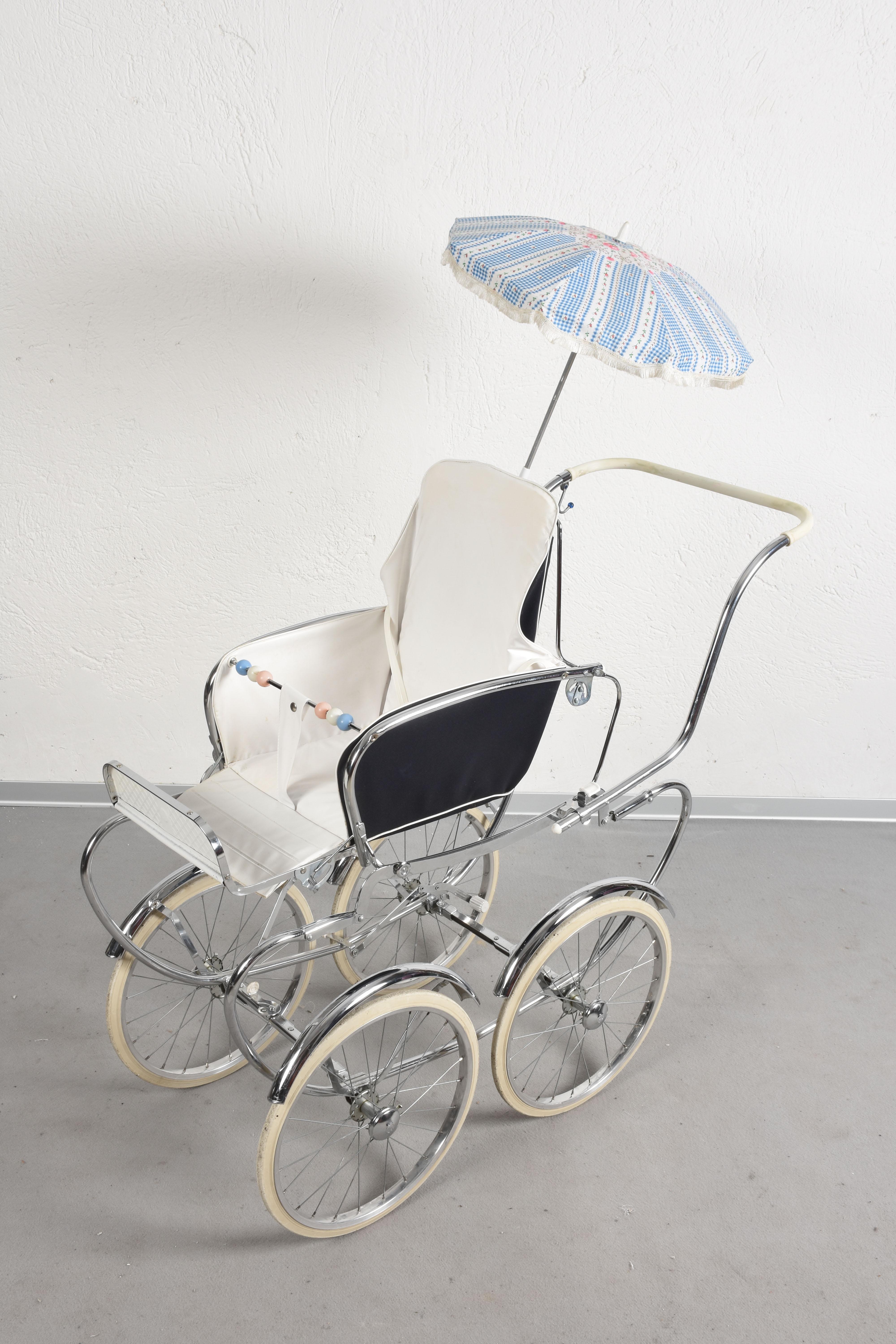 Cute midcentury steel and white fabric Italian baby pram stroller. This marvelous item was produced in Italy during the 1950s.

This pram stroller comes with a vintage umbrella, large wheels and the perfect combination between fabric and
