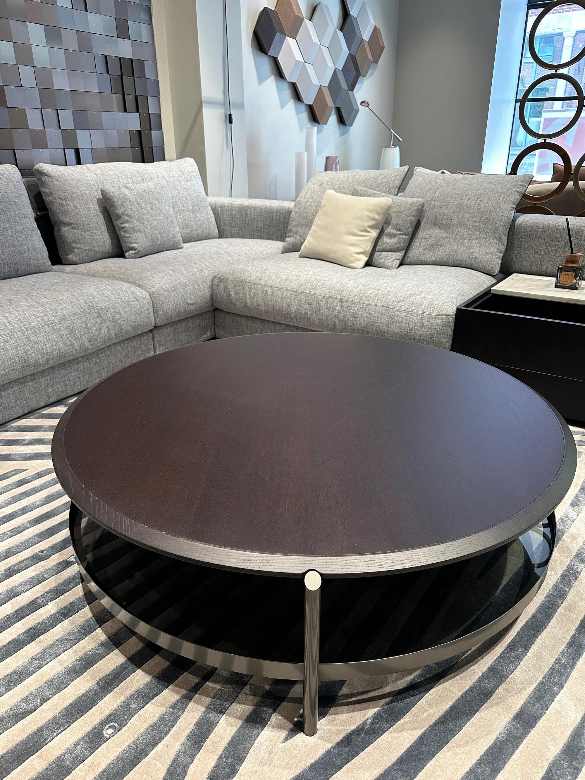 La table basse Skyline présente un design rond et élégant avec du bois foncé teinté noyer et une solide base en métal moulé sous pression, combinant style et fonction sans effort.

Plateau : Noyer teinté foncé 2Z
Structure : En métal finition étain