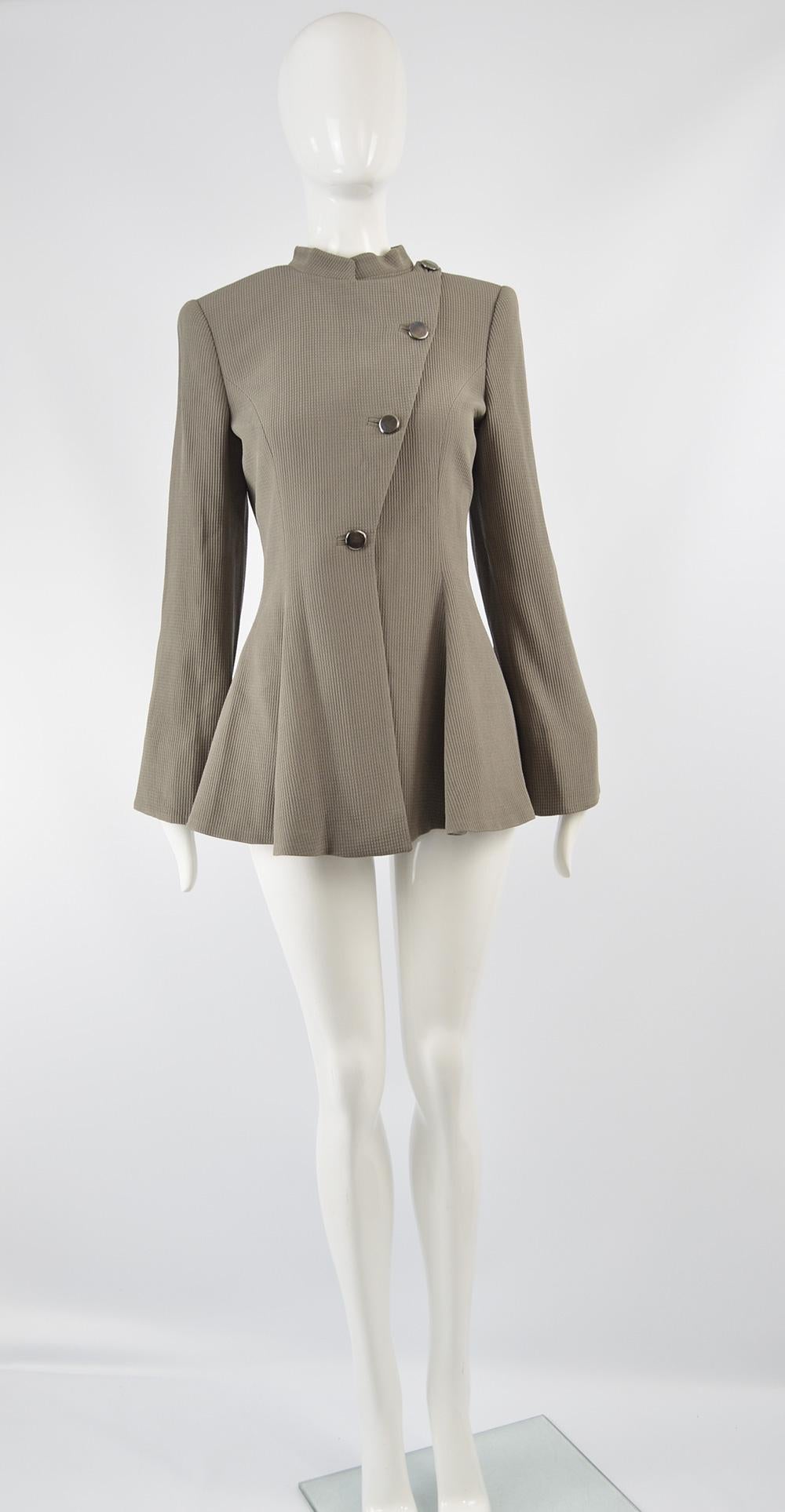 A stunning and avant garde vintage women's evening jacket from the fall winter 2004 collection by legendary Italian fashion designer, Giorgio Armani. Made in Italy, in a taupe colored textured silk and wool fabric with satin lapels and a military