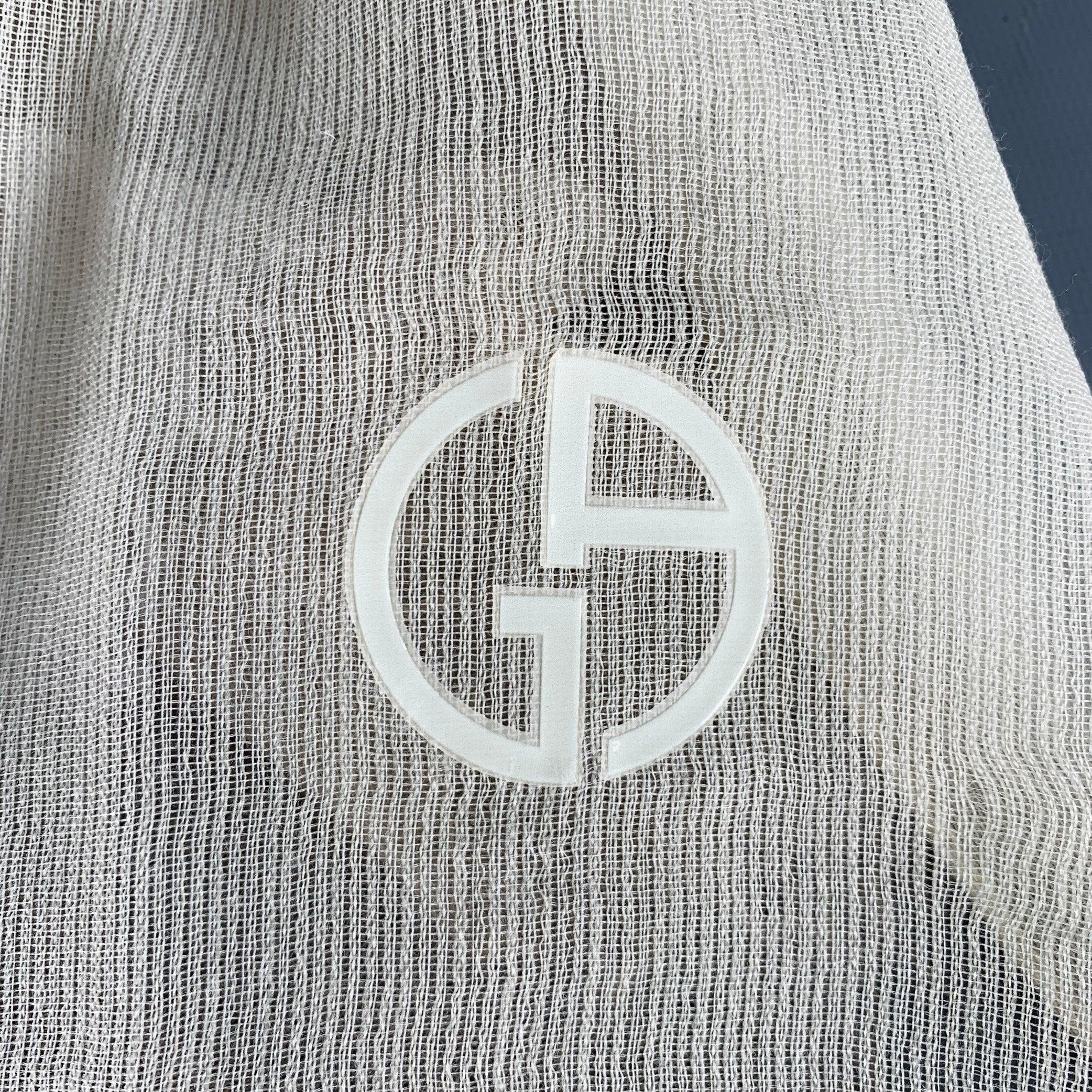 GIORGIO ARMANI scarf
in a beige and taupe wool blend woven fabric featuring an ombre design, raw edges, and rubber monogram logo detail.Very Good Pre-Owned Condition. Minor snag. 

Measurements: 
  70 inches  x 31 inches 
  
  
 
Sui Generis