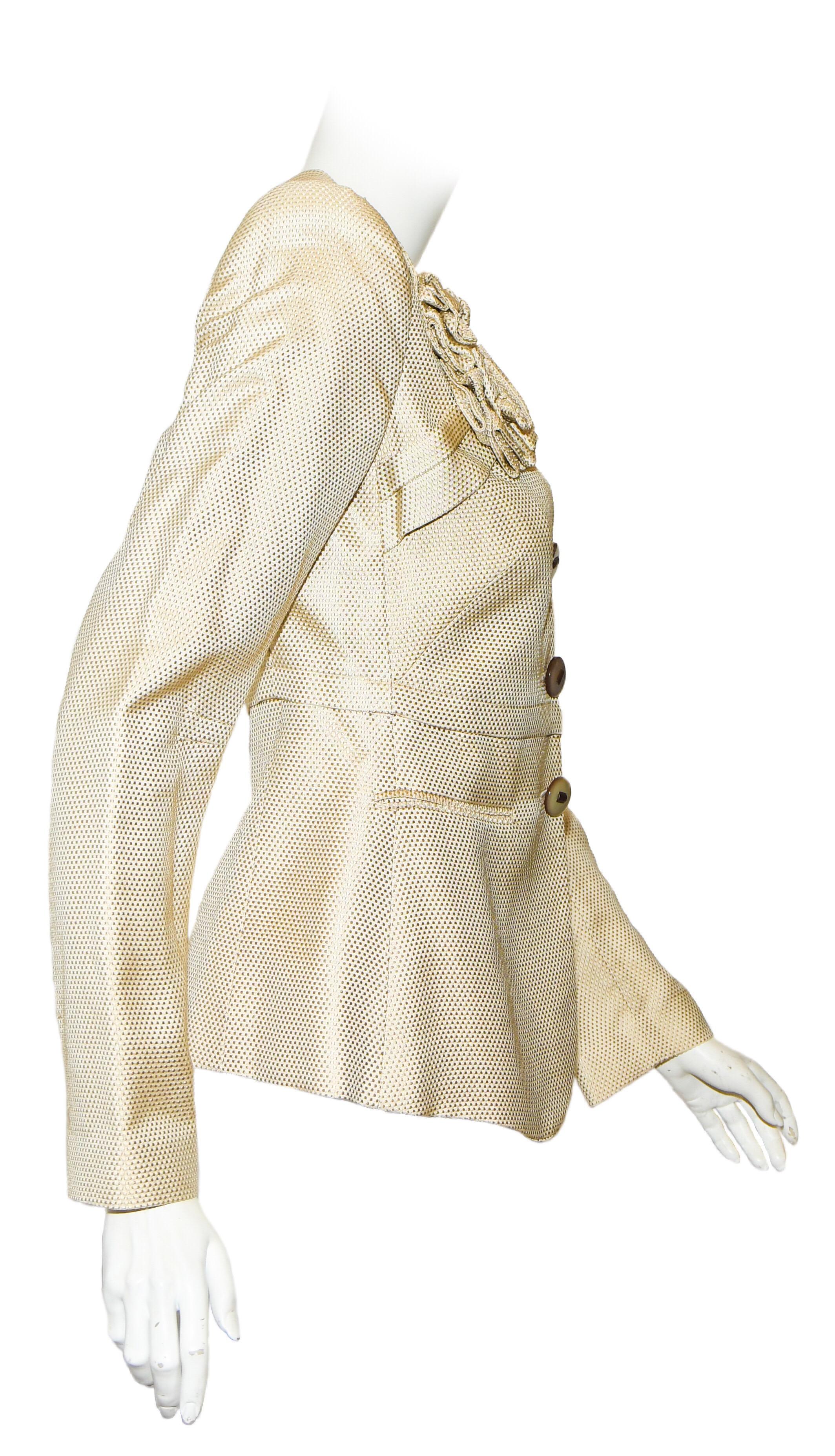 Giorgio Armani beige textured brocade is decorated with a fabric corsage created from same fabric.  Features fitted silhouette, two front welt pockets (sewn shut) and 3 large acrylic buttons.  This garment is lined in beige viscose and is in good