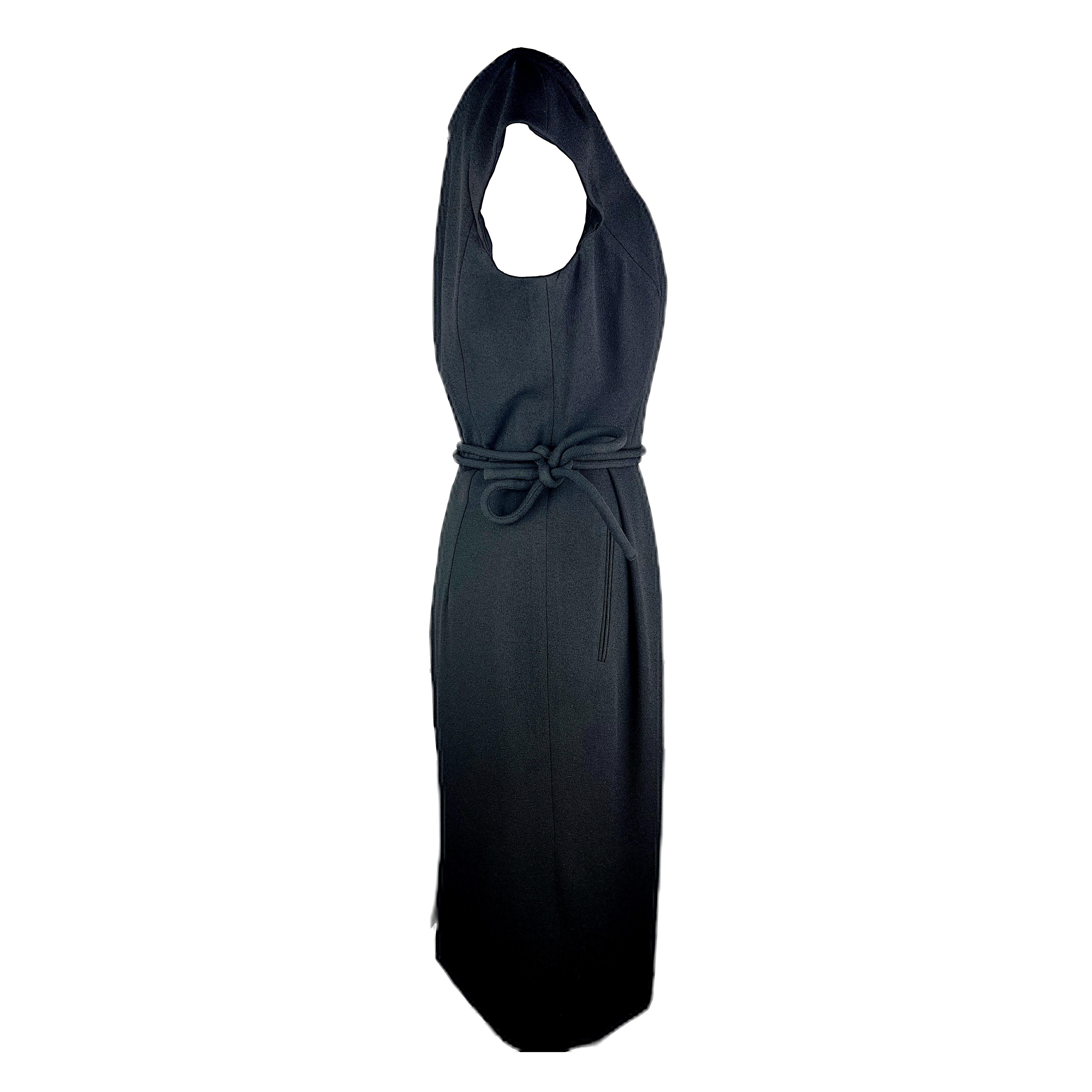 Here is a classic piece in Armani's design style: it's a blouson dress with a beautiful waist belt that can be tied either on the front or right hand side. The fabric is a black synthetic crepe and the dress is fully lined with fine sewings.