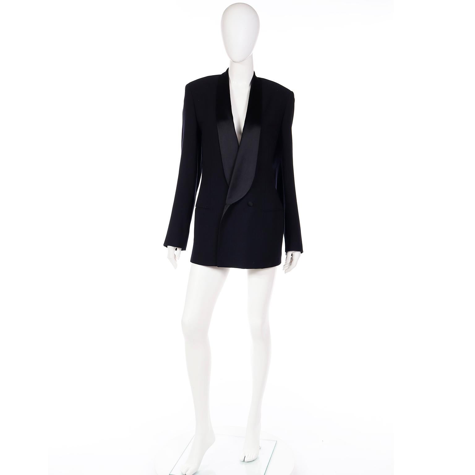 This stunning vintage Giorgio Armani black wool blazer with black silk satin lapels and black satin silk covered buttons. This particular jacket is uniquely designed with a very low V front.  We love these Armani vintage tuxedo jackets and this one
