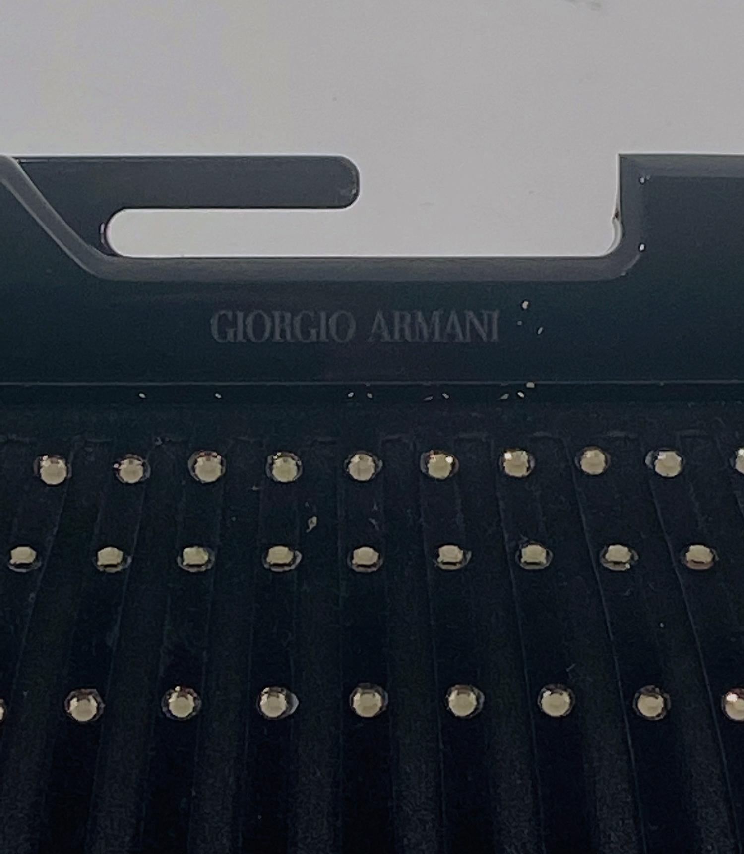Sac de soirée Giorgio Armani en daim noir et satin noir serti de cristaux Swarovski, le sac a un cadre acrylique noir et une fermeture à bouton pression. Le sac possède une chaîne dorée qui peut être utilisée ou glissée à l'intérieur pour porter le