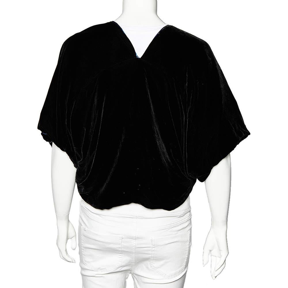 This cropped shrug from Giorgio Armani is gorgeous! It has one side in black velvet and the other side in blue satin — a versatile quality that allows two different looks. The shrug has an open front and a cropped hemline.

