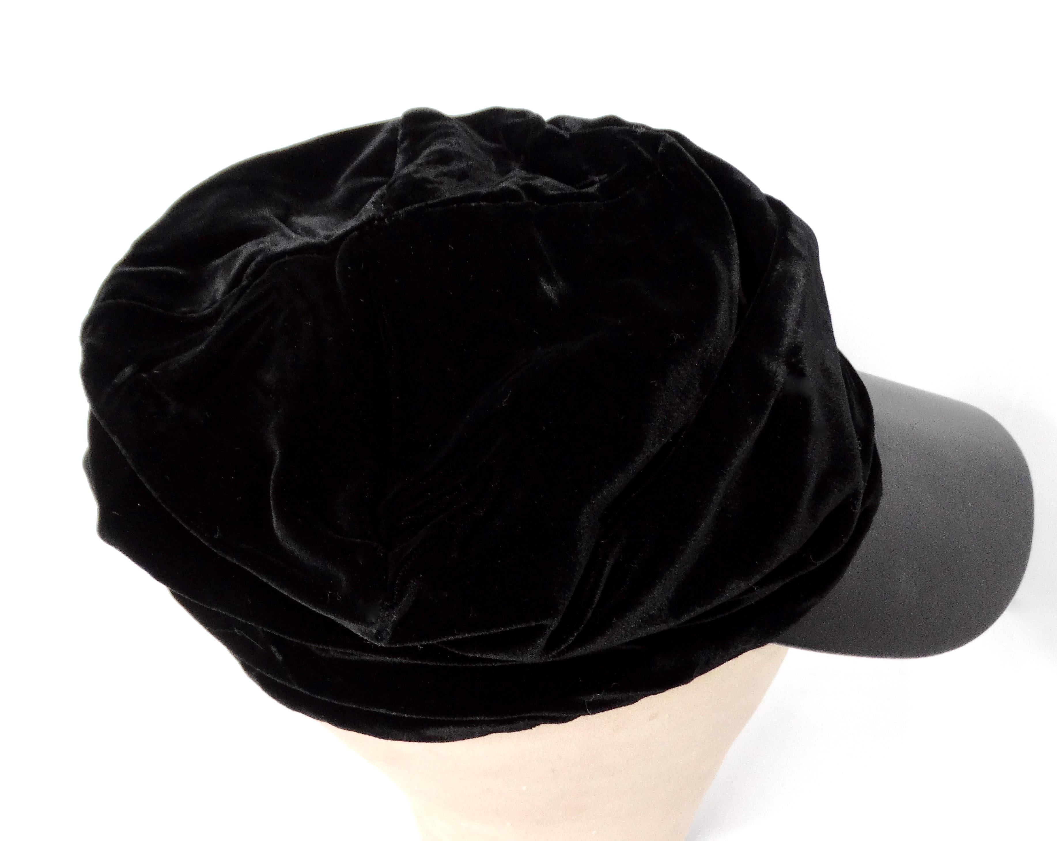 Le chapeau Giorgio Armani en velours noir à bords froncés en cuir, datant de l'an 2000, est un accessoire sophistiqué et polyvalent qui capture l'essence de la mode de luxe du début des années 2000. Fabriqué en velours noir pelucheux, le tissu