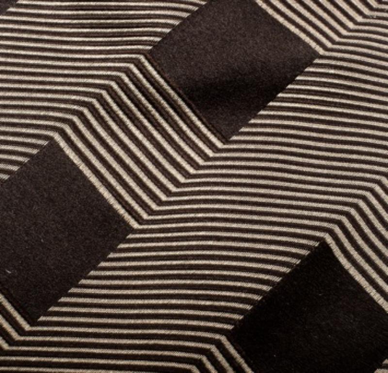 Esta corbata Giorgio Armani tiene un increíble estampado jacquard que adorna maravillosamente su discreta base marrón. Cortada en exquisita seda, la corbata se completa con un lazo de sujeción y el tradicional extremo en punta.