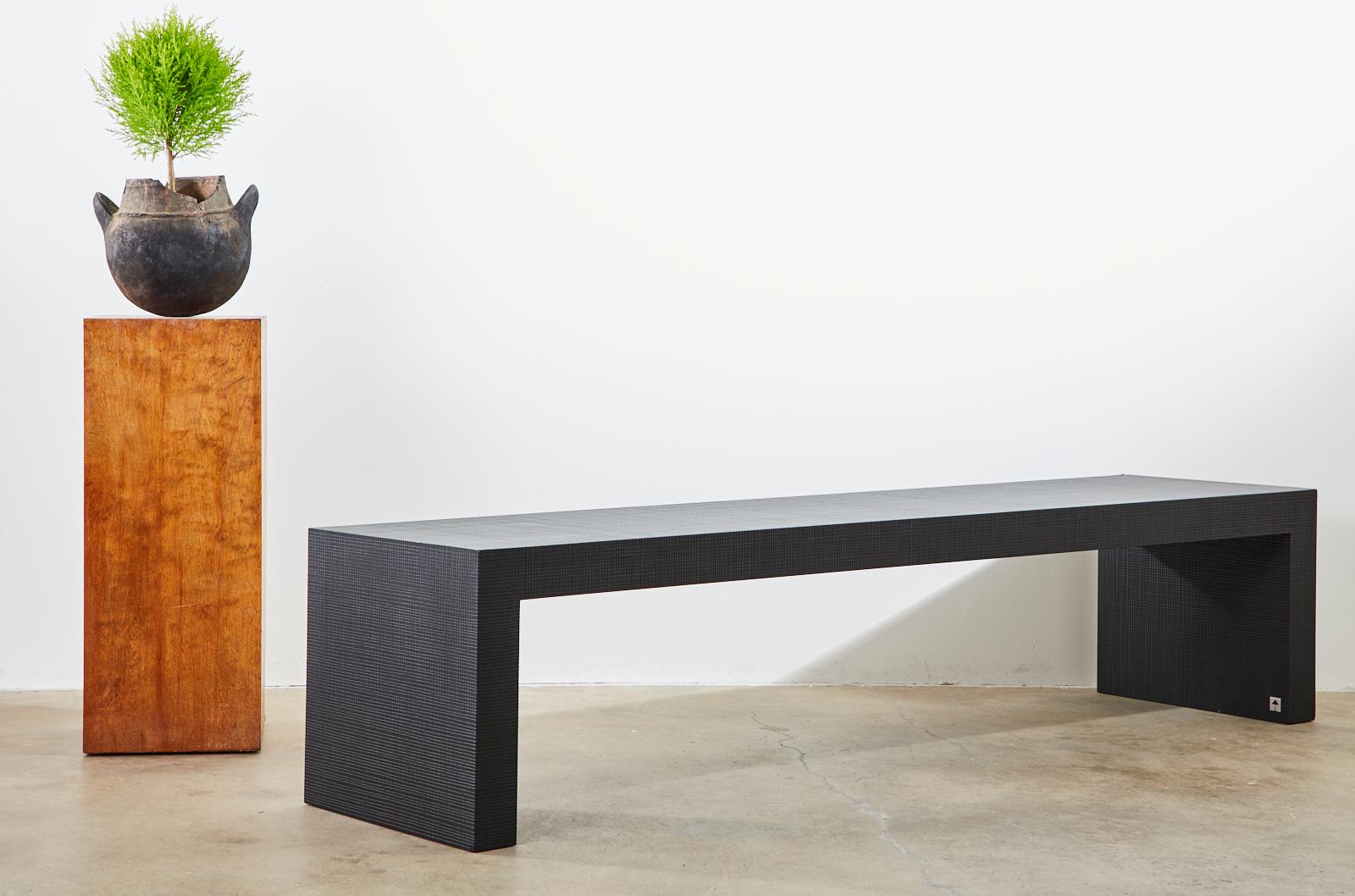 Dramatic coffee cocktail low table or bench designed by Giorgio Armani for Armani Casa. Features an ebonized wood finish with a subtle geometric pattern design on the wood. Minimalist style that could also serve as a low console table behind a sofa