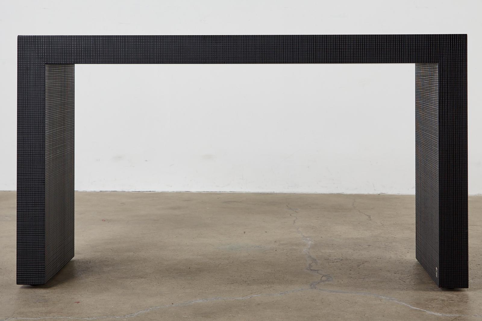 Exceptionnelle table d'écriture ou console réalisée par Armani Casa pour Giorgio Armani. Cette pièce présente une finition en bois ébonisé spectaculaire avec un motif géométrique subtil sur la finition. Design minimaliste avec des pieds réglables à