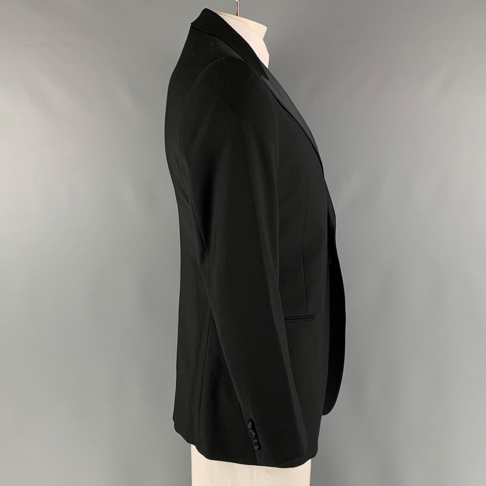 EMPORIO ARMANI tuxedo sport coat comes in a black wool woven material with a full liner featuring a peak lapel, welt pockets, and a single button closure. Made in Italy. Excellent Pre-Owned Condition.  

Marked:   52 

Measurements: 
 
Shoulder:
