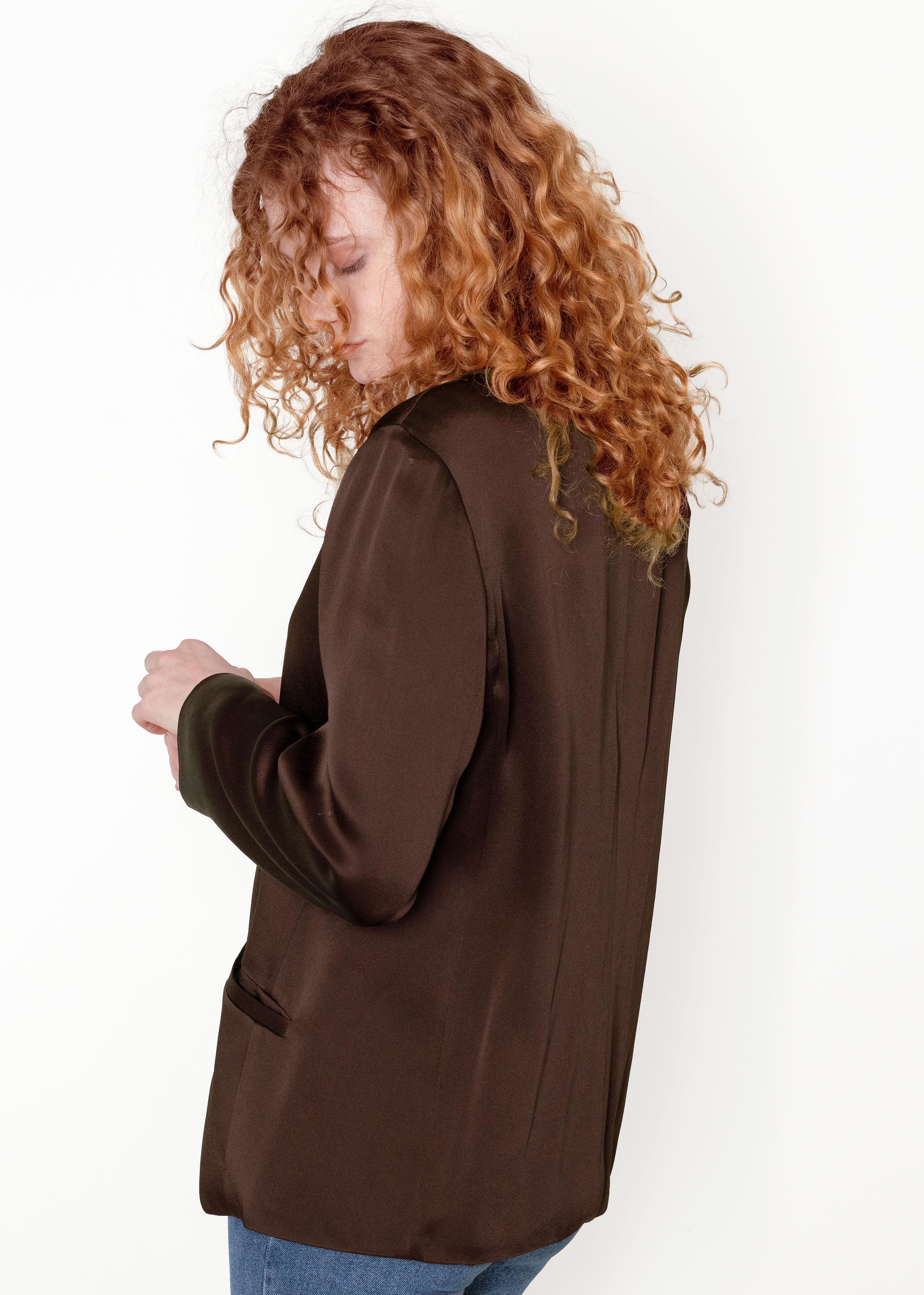 This beautiful Armani collezoni button up brown blouse is made with 65% acetate and 35% rayon, with a 100% polyester lining for comfort. The satin fabric adds a touch of luxury to any outfit. The hidden buttons and two pockets add a unique touch of