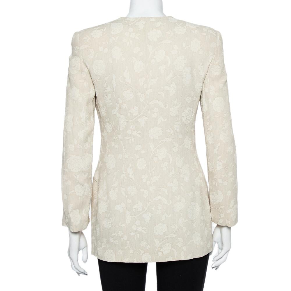 Attirez l'attention en portant ce blazer Vintage de Giorgio Armani. Ce blazer crème confortable et élégant est conçu dans un style simple avec des détails de cravate sur le devant, un motif floral sur toute la surface et des manches longues.