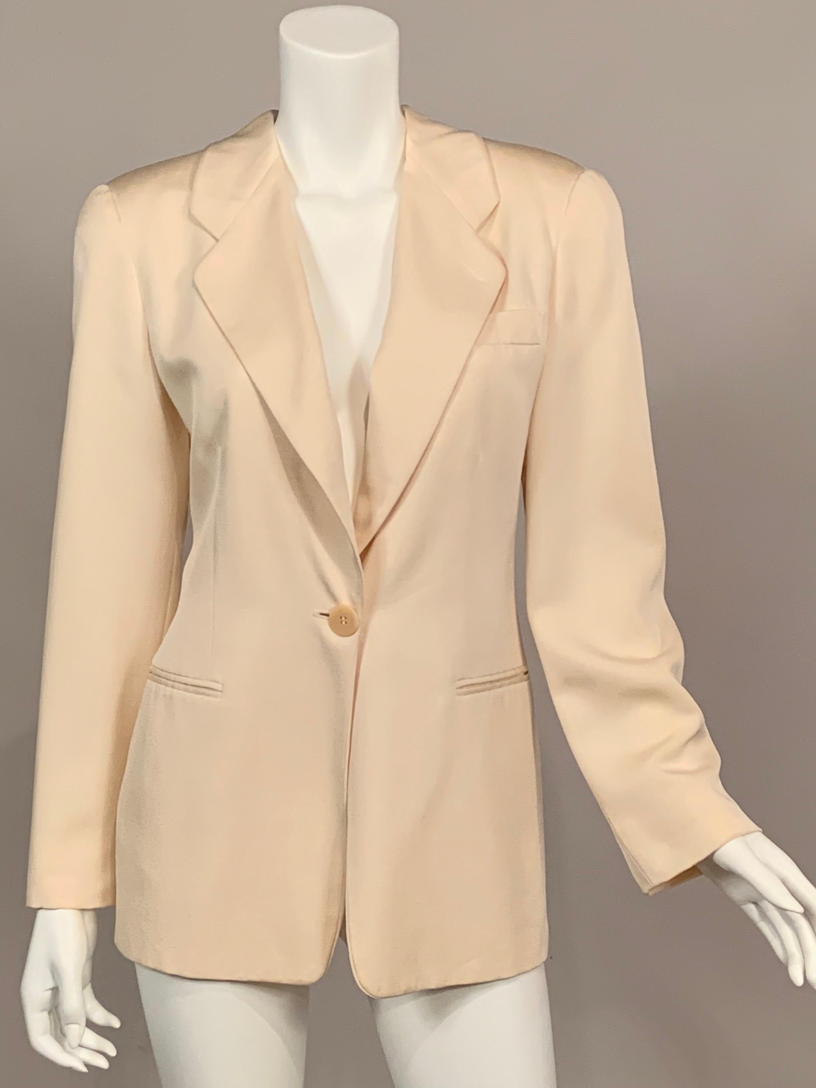 Giorgio Armani has updated the classic one button blazer in cream silk with notched lapels, one breast pocket and two hip pockets, [all still stitched closed], and a single button on each cuff. The jacket is lined in a matching silk blend and it is
