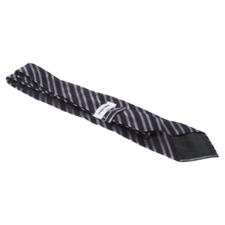 Questa cravatta di Giorgio Armani è perfetta da aggiungere alla tua collezione! Questa creazione viola scuro è realizzata in 100% seta e presenta strisce diagonali su tutta la superficie. È dotato di un passante e dell'etichetta del marchio ben