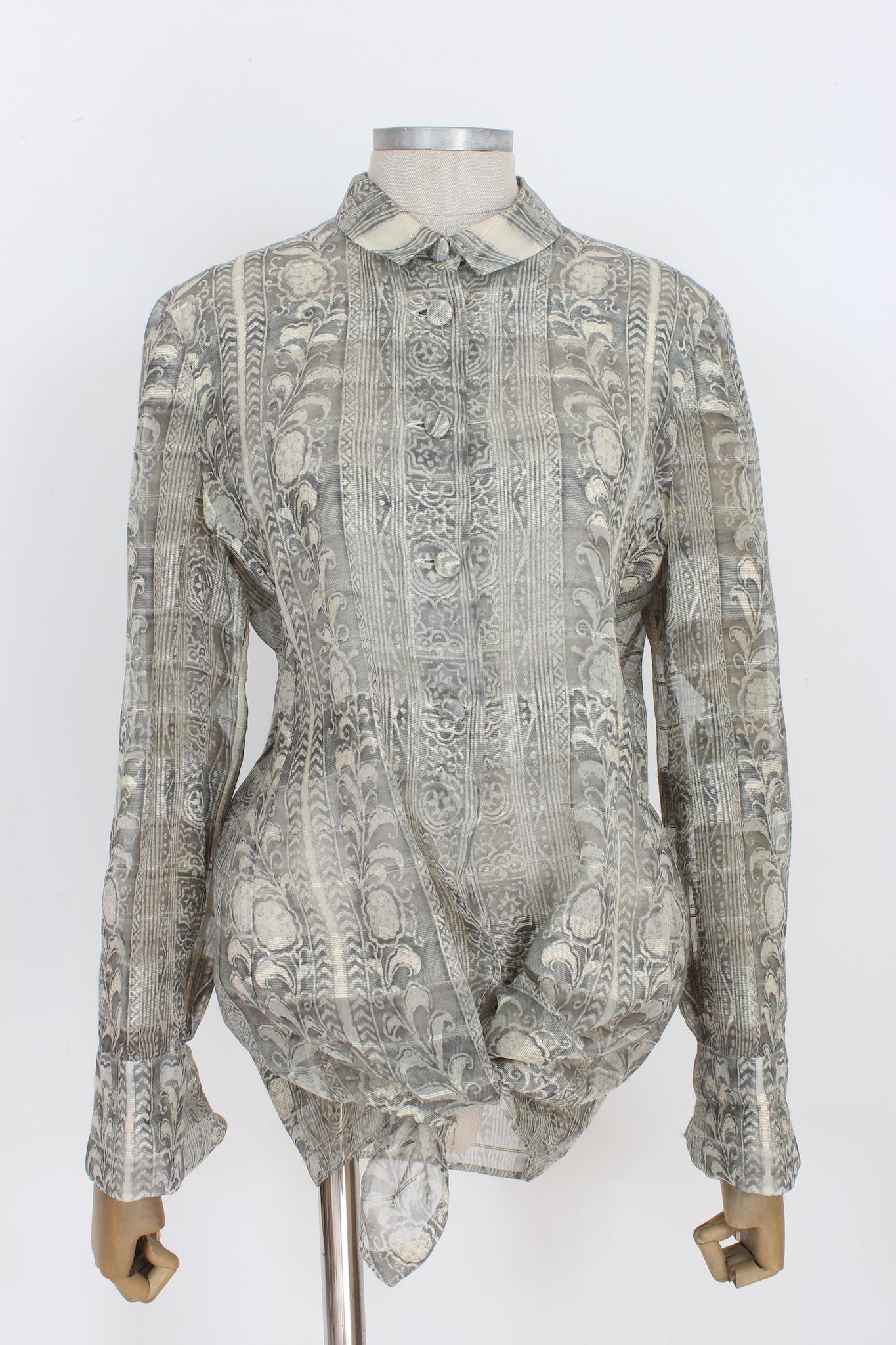 Giorgio Armani classic vintage 90s shirt. Gray and beige color with floral designs, 100% transparent silk fabric. Covered buttons, peculiarity in the sleeves, possibility of closure with cufflinks. Made in Italy.

Size: 46 It 12 Us 14 Uk

Shoulder:
