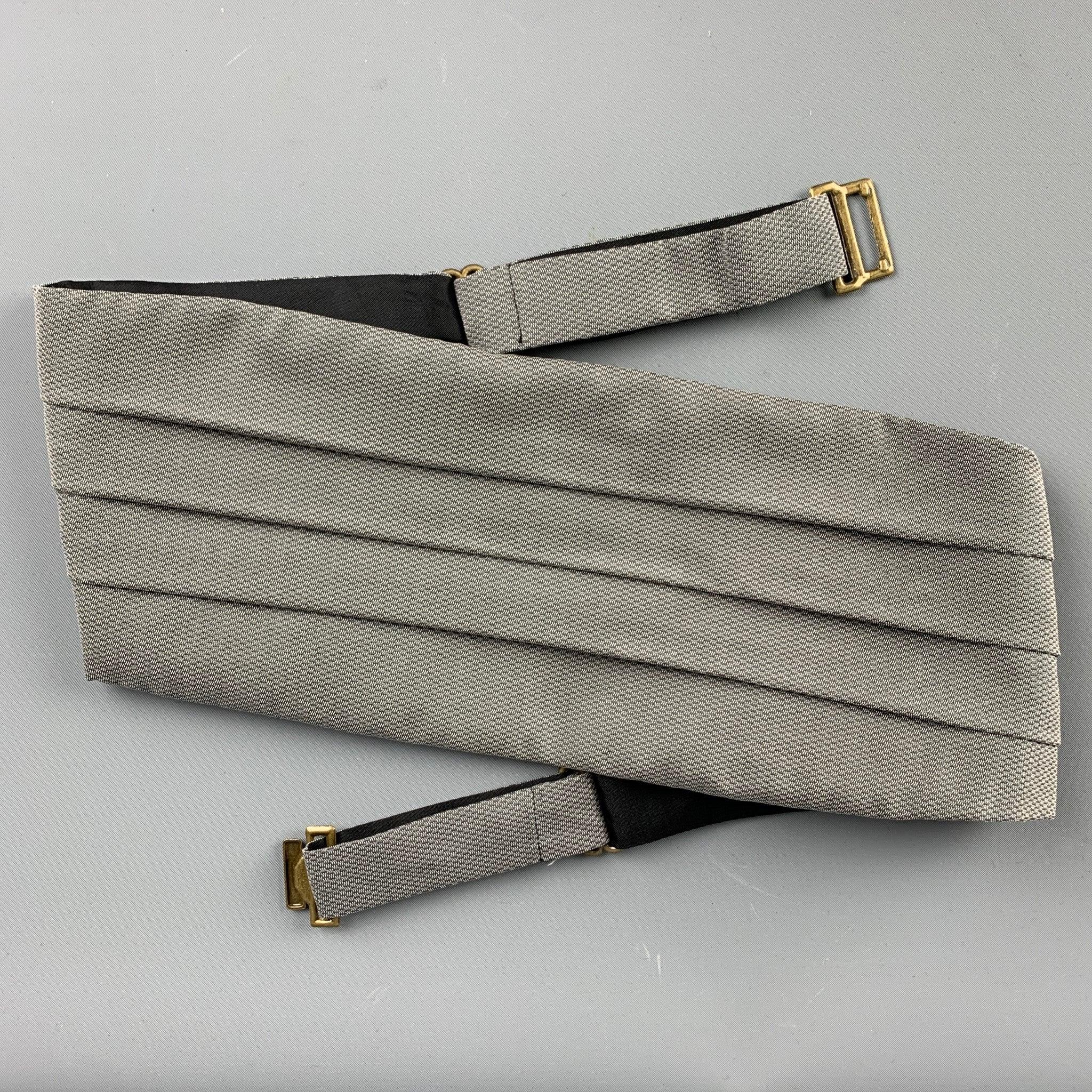 GIORGIO ARMANI
cummerbund set in a grey blue silk fabric featuring a nailhead pattern, and a matching pre-tied bow tie. Comes with box. Made in USA. Very Good Pre-Owned Condition. 

Measurements: 
  - Cummerbund. Height: 5.5 inches Length: 36 inches
