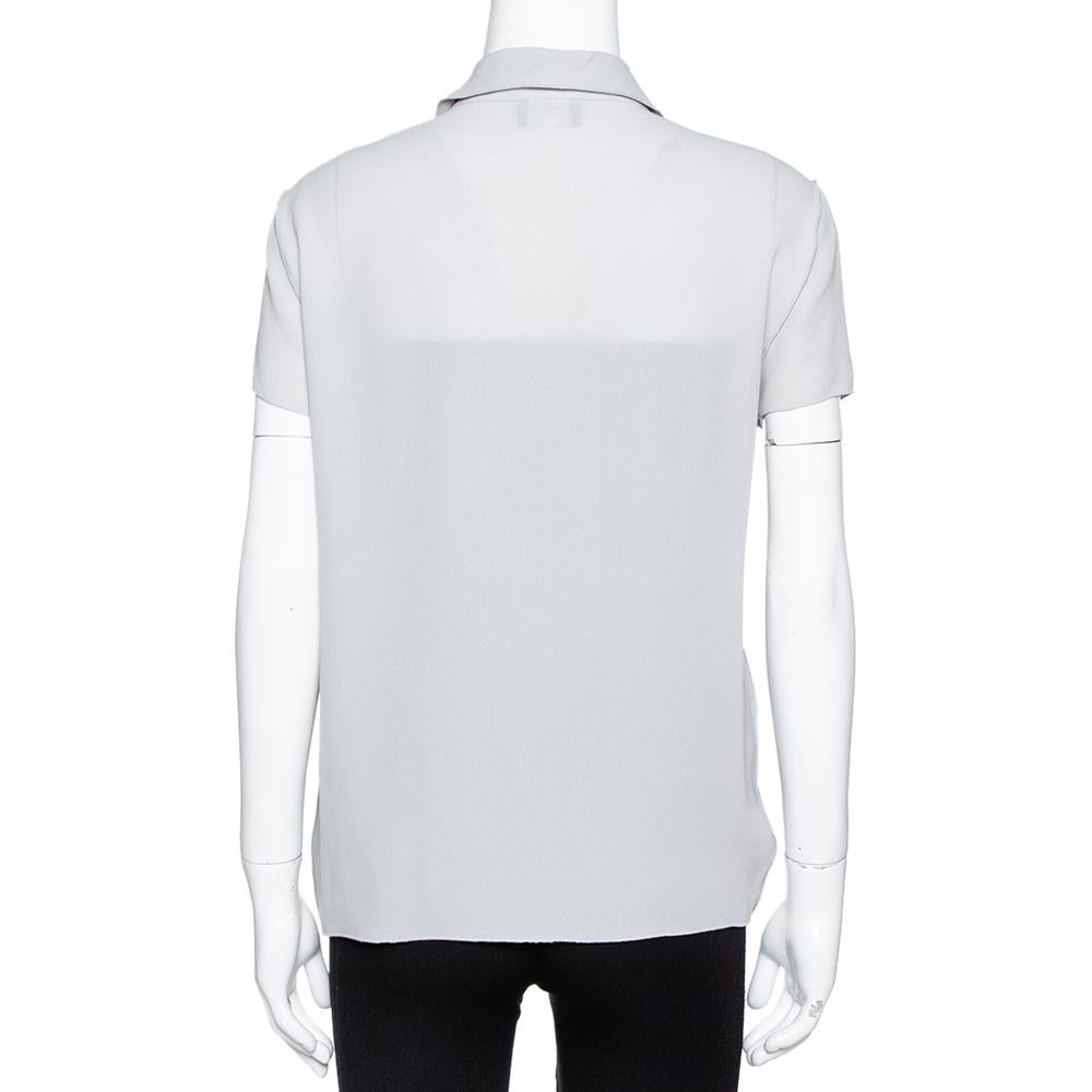 Exuding poise and sophistication, this blouse from Giorgio Armani will elevate your style quotient instantly. The grey creation features an open front silhouette and a single button fastening. It has short sleeves and will look best with black pants