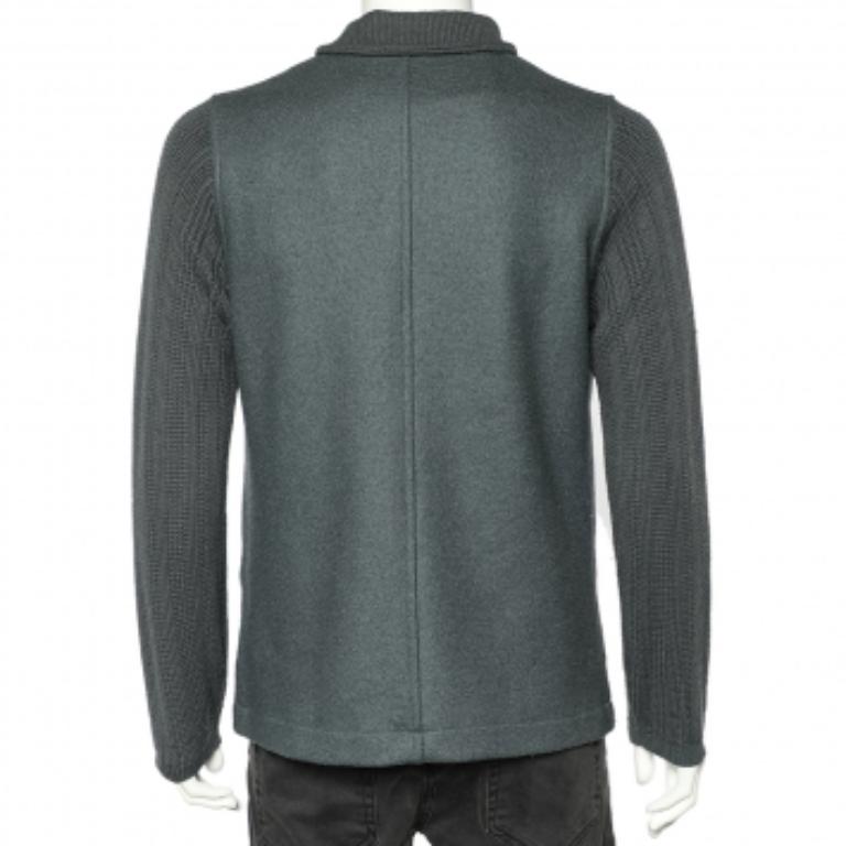 Elegante y con estilo, esta chaqueta de la Casa Giorgio Armani añadirá un toque de tendencia a todos tus looks. Está diseñado en tejido de lana gris y presenta mangas con detalles de punto. Tiene un estilo frontal abotonado y dos bolsillos