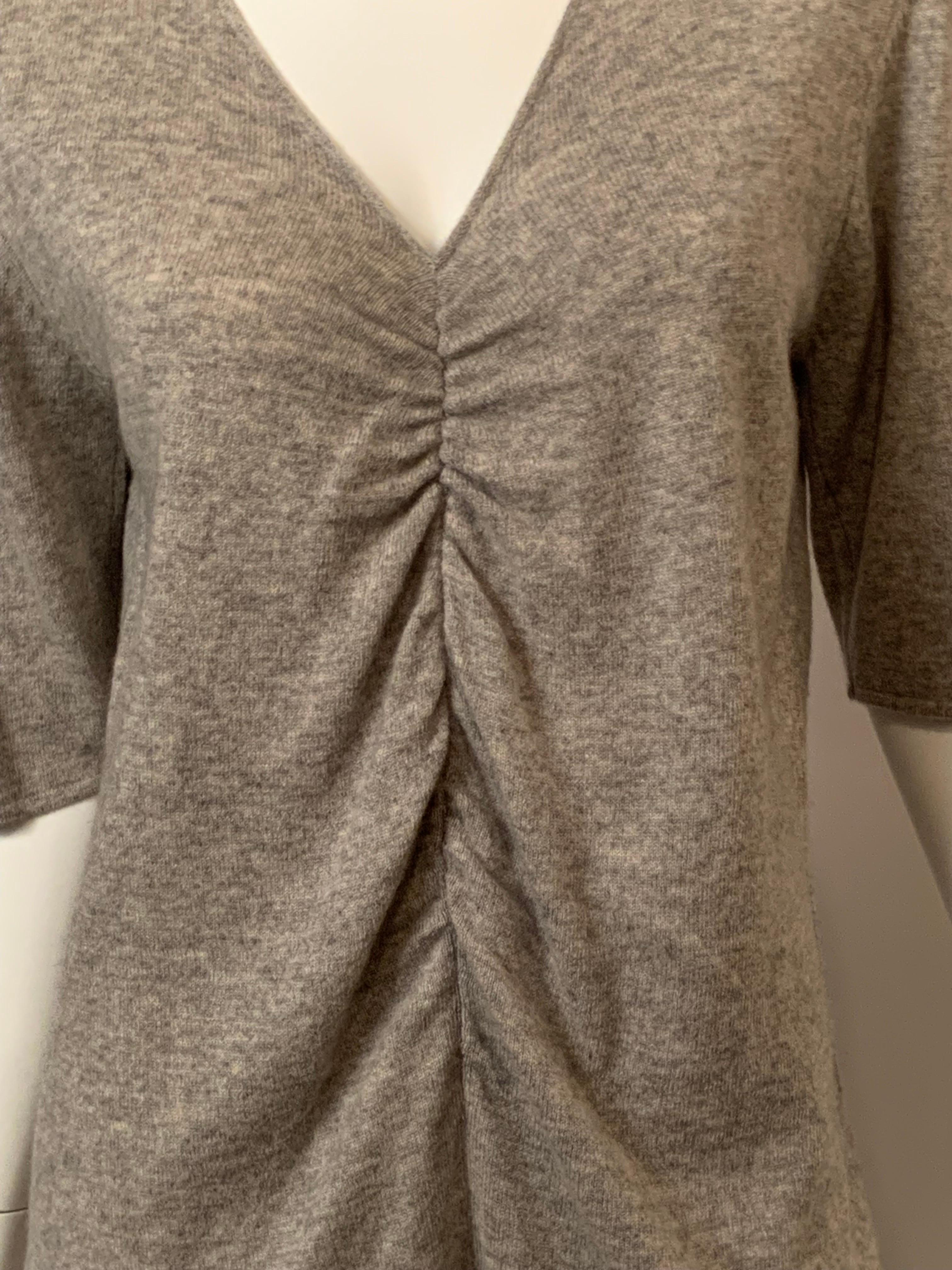 Giorgio Armani designed this heather grey cashmere sweater in the 1980's.  With the ease of a T shirt t has a V neckline, gathering at the center front, and elbow length sleeves.  All of the original tags are still attached.  It is in excellent