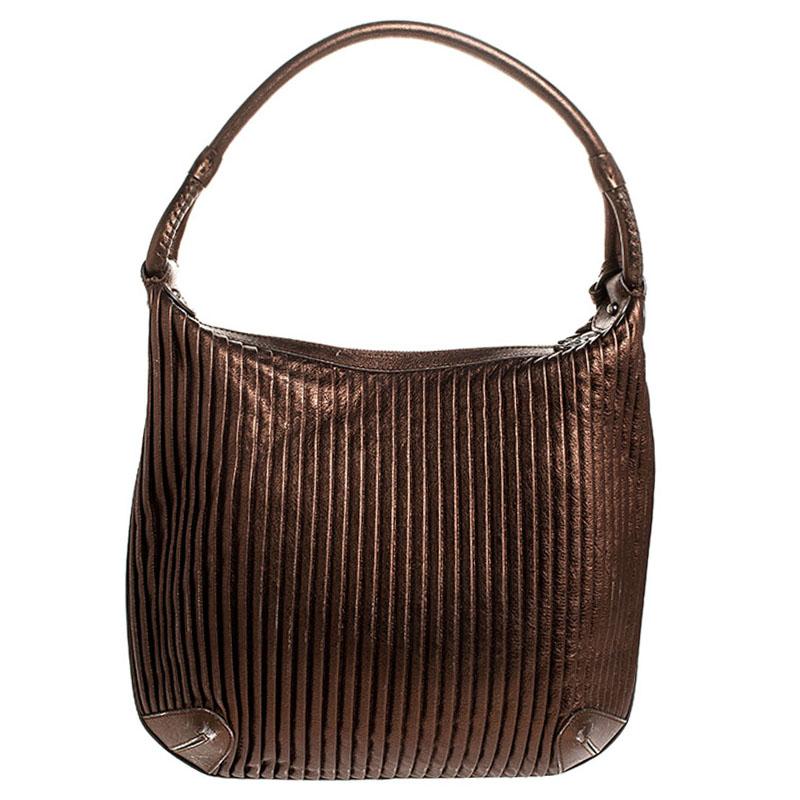 Elevate your day to day look by carrying this sleek Giorgio Armani handbag from work to weekend. Made from metallic brown leather, carry all your essentials in this fashionable and comfortable bag. Lined with suede, the interior of this bag is as