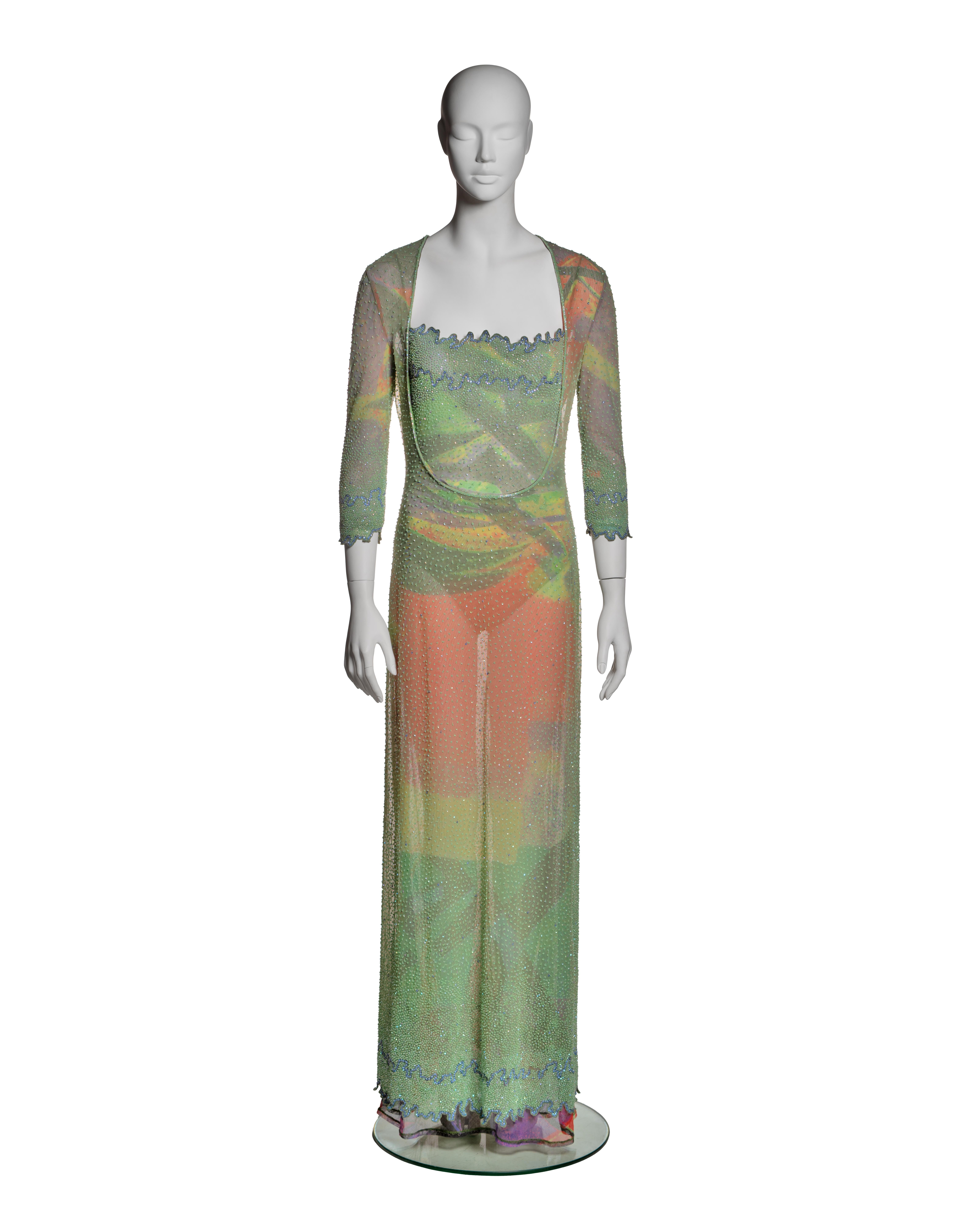 This Giorgio Armani ensemble from the Spring-Summer 2000 collection consists of a sheer floor-length dress with an accompanying bodysuit. The dress features a lightweight, translucent mesh outer layer adorned with micro faceted and bugle beads,