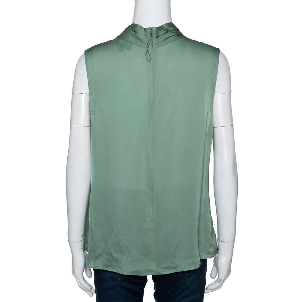 This stunning blouse comes from the house of Giorgio Armani. Crafted from a silk blend, it features a pale green shade. The blouse comes with a sleeveless design, back zipper and draped detailing. It is just right to deliver a chic look instantly.

