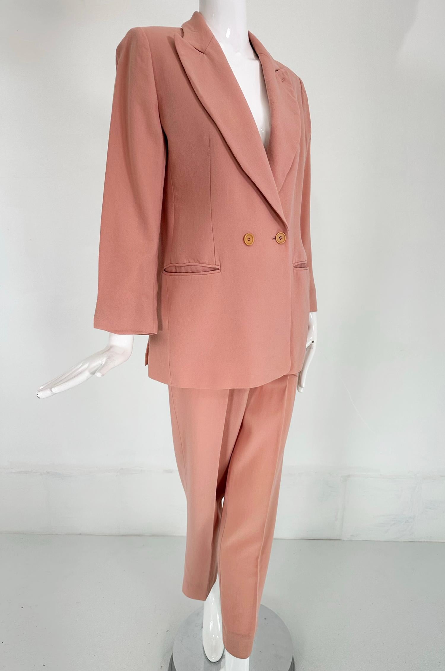Giorgio Armani Peach Lightweight Wool Double Breasted Pant Set from the early 1990s. Double breasted jacket closes at the waist with two buttons, notched lapels and besom pockets at the hip fronts. The jacket has side hem vents at the back, fully